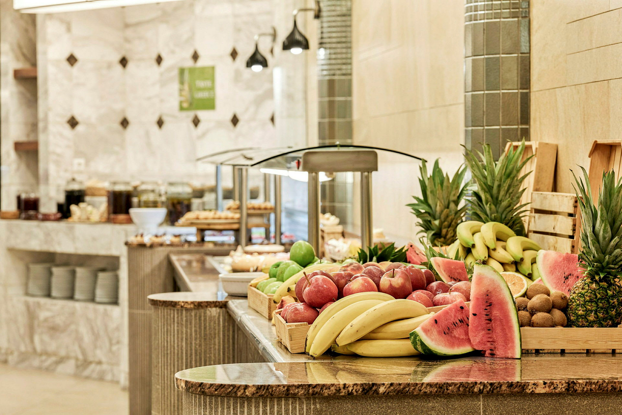 En buffé med färsk frukt inklusive bananer, äpplen, ananas och vattenmelon. (AI-genererad text)
