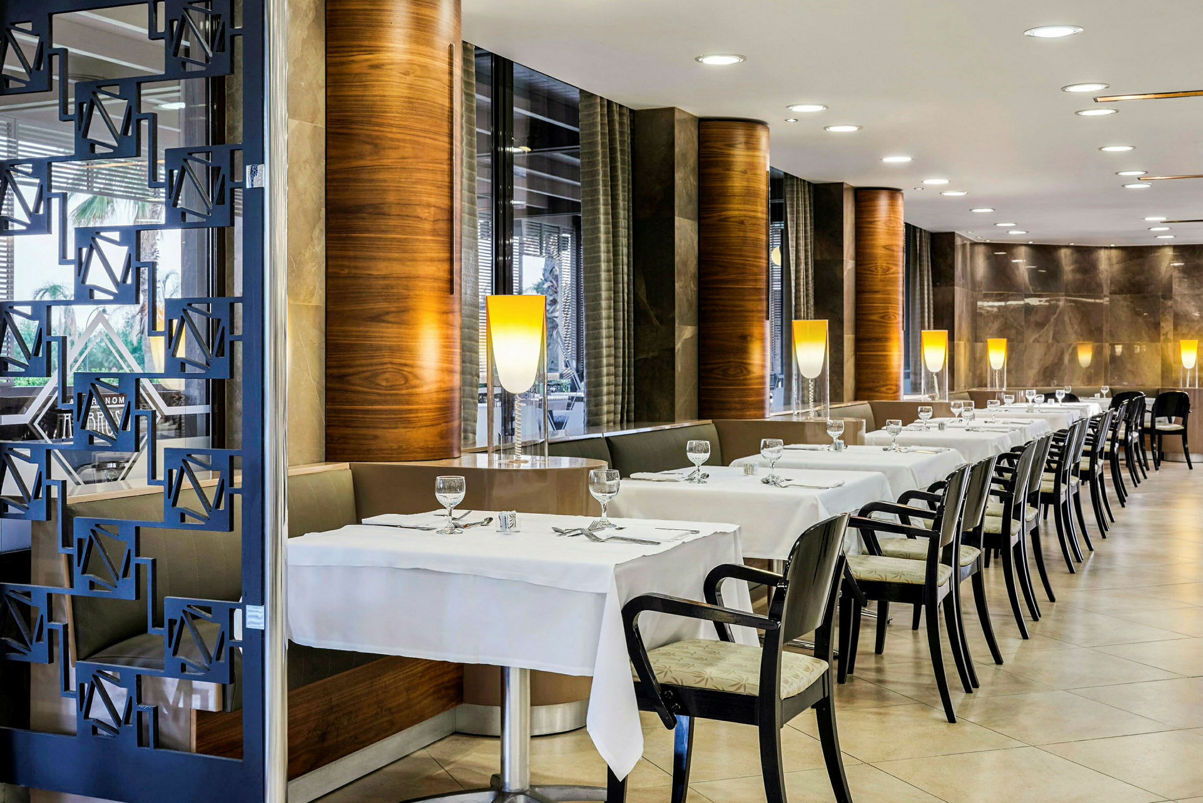 Interiör av en restaurang med dukade bord och stolar. (AI-genererad text)
