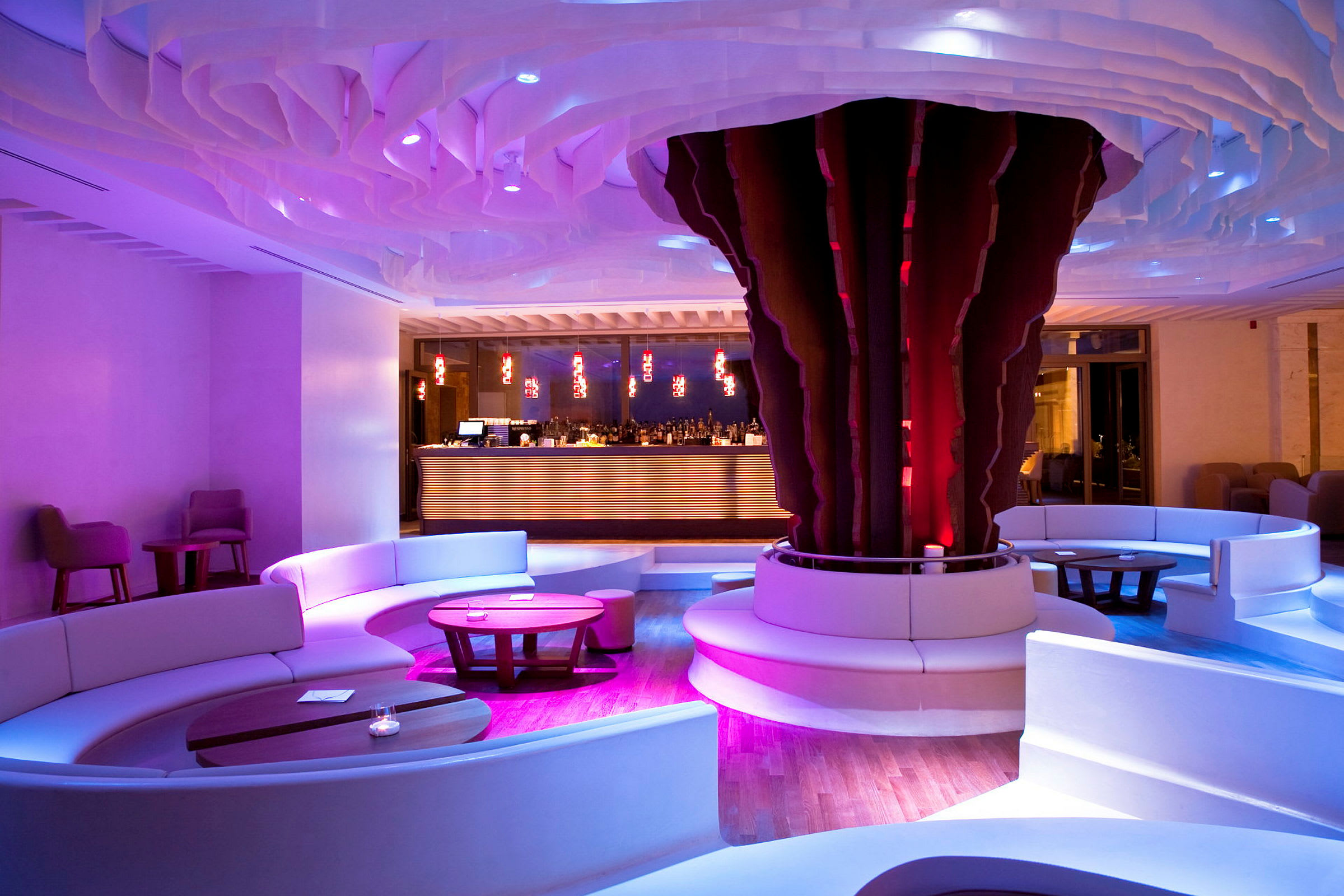 En modern hotellounge med rund sittgrupp, bord och en färgglad interiör. (AI-genererad text)