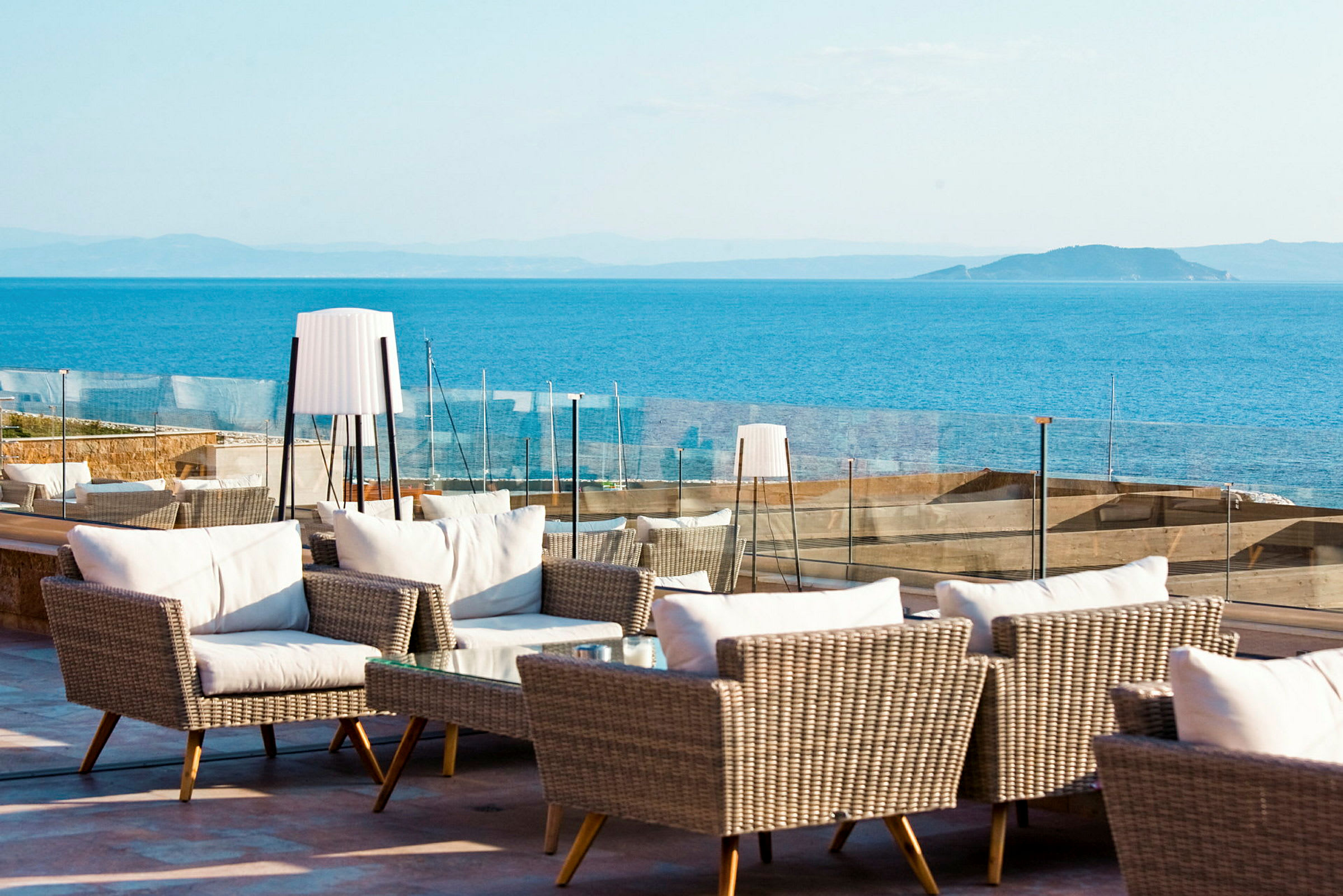 Utomhuslounge med rottingmöbler och utsikt över havet. (AI-genererad text)