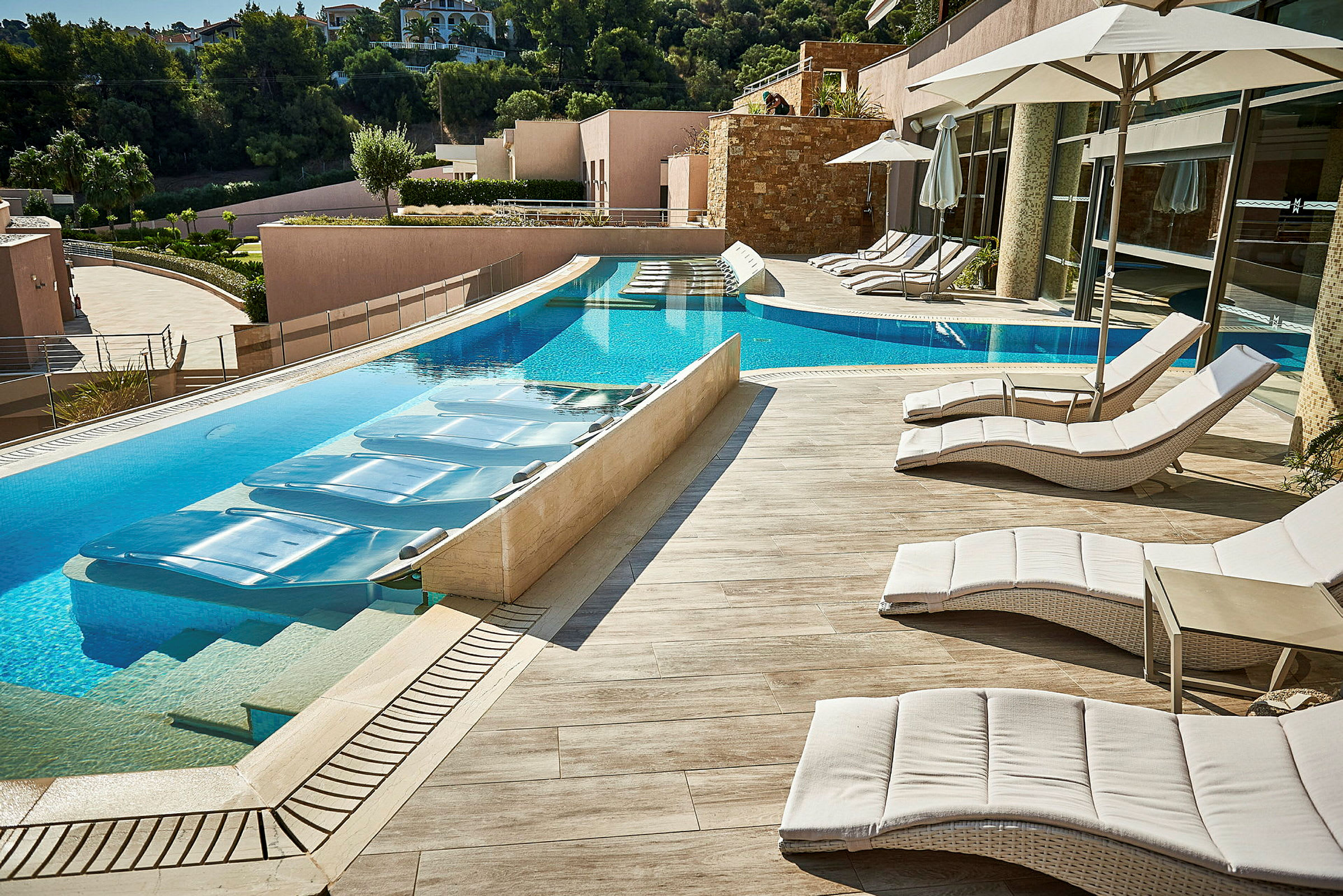 Solstolar och parasoll vid en pool på en hotellterrass. (AI-genererad text)