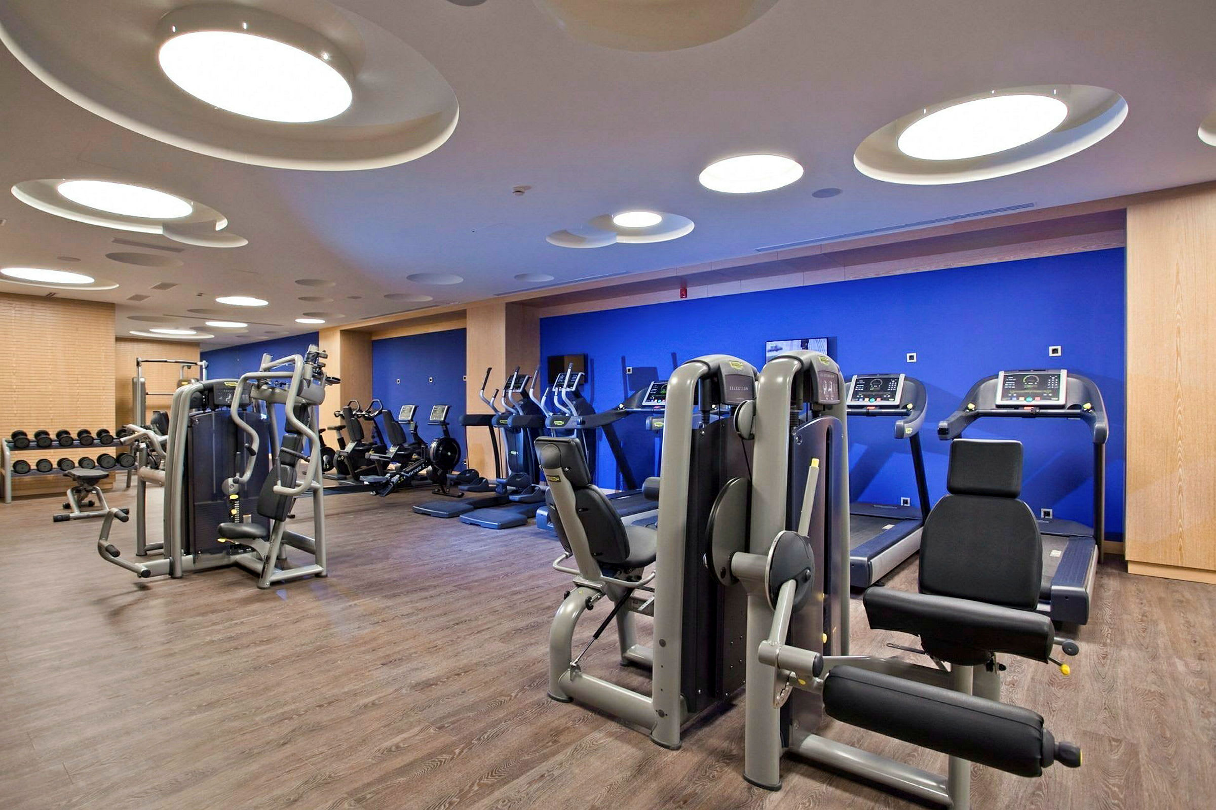 Ett modernt gym med träningsmaskiner, löpband och vikter. (AI-genererad text)