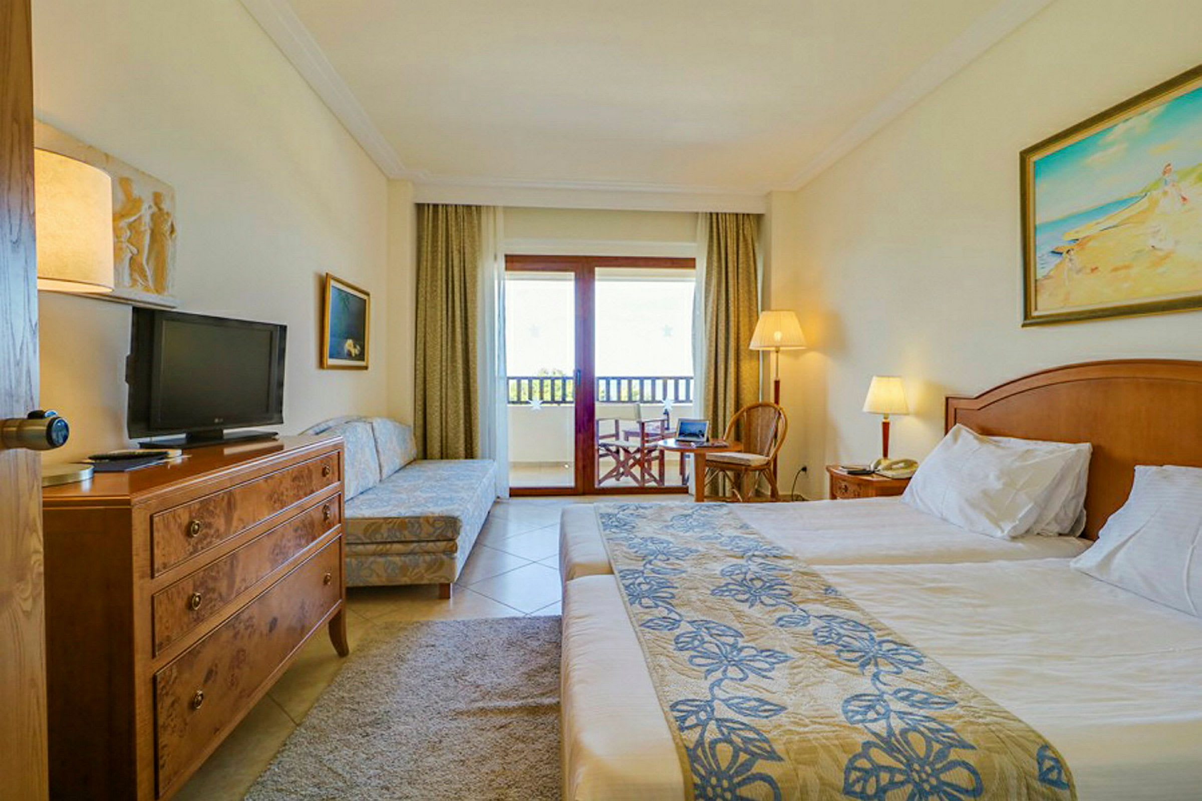 Ett hotellrum med en dubbelsäng, tvättmöbel, soffa, och balkong med utsikt. (AI-genererad text)