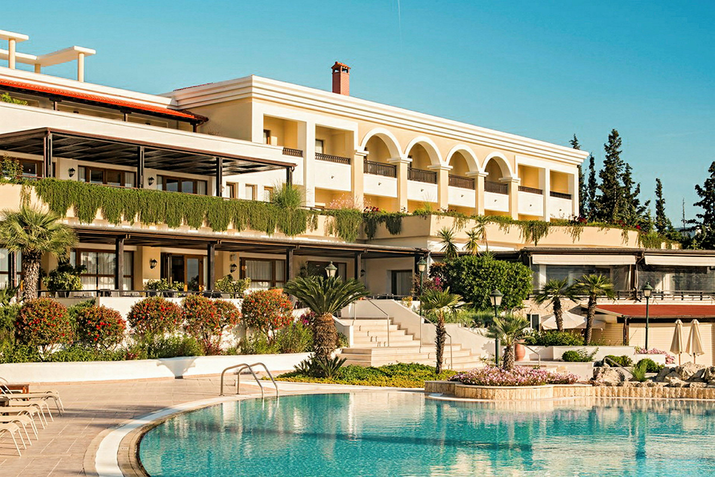 Bild av en hotellbyggnad med pool i förgrunden. (AI-genererad text)