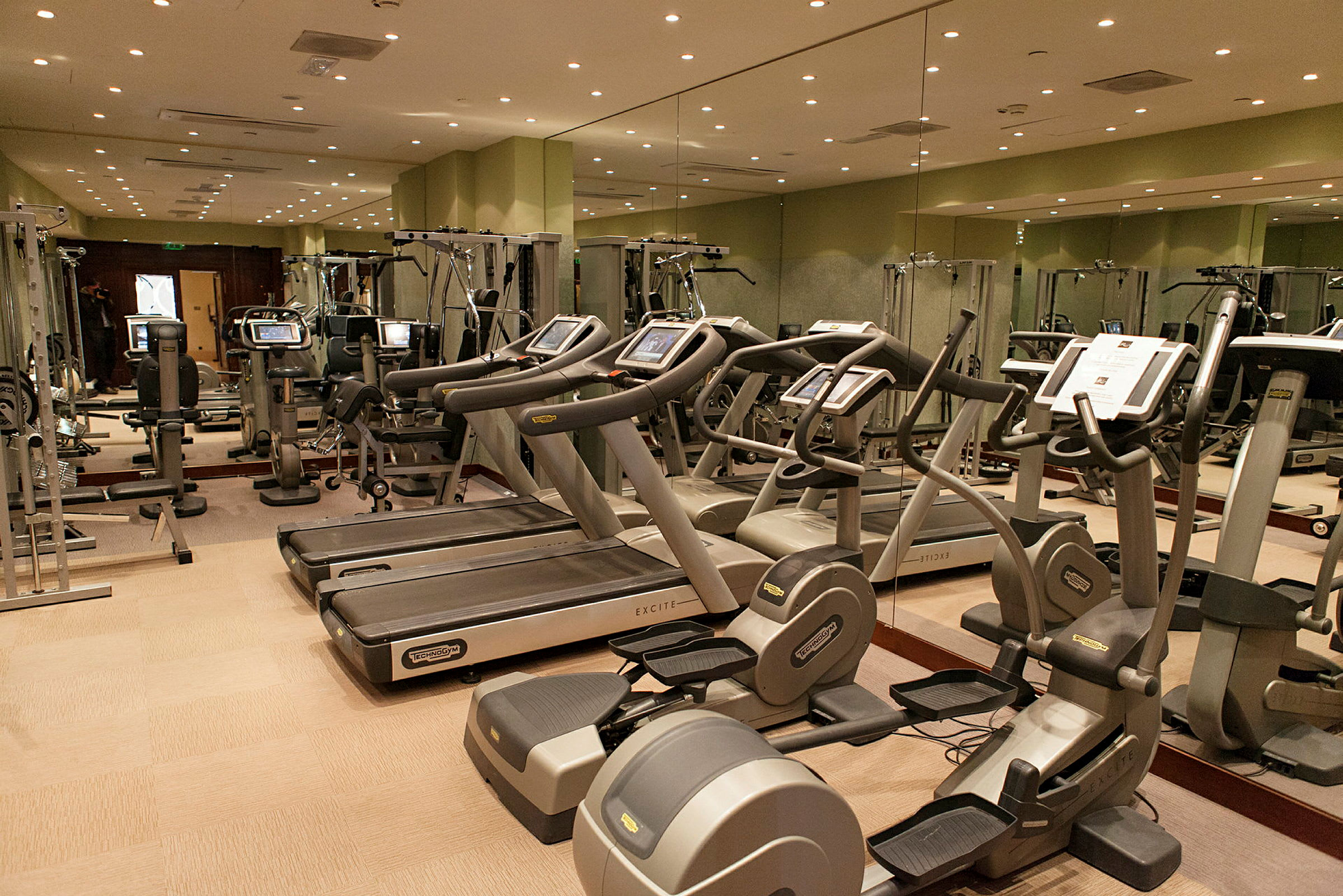 Bild på ett gym med träningsmaskiner såsom löpband och motionscyklar. (AI-genererad text)