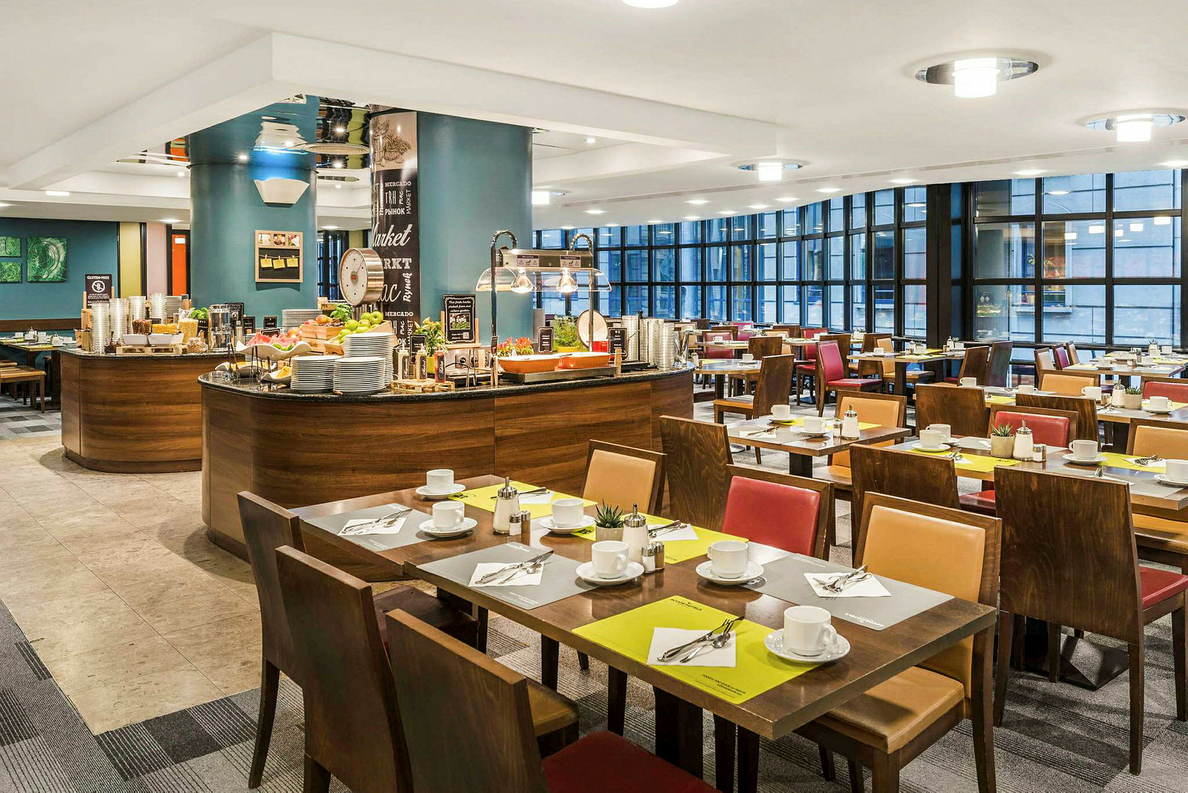 En restauranginteriör med dukade bord och en bufféstation. (AI-genererad text)