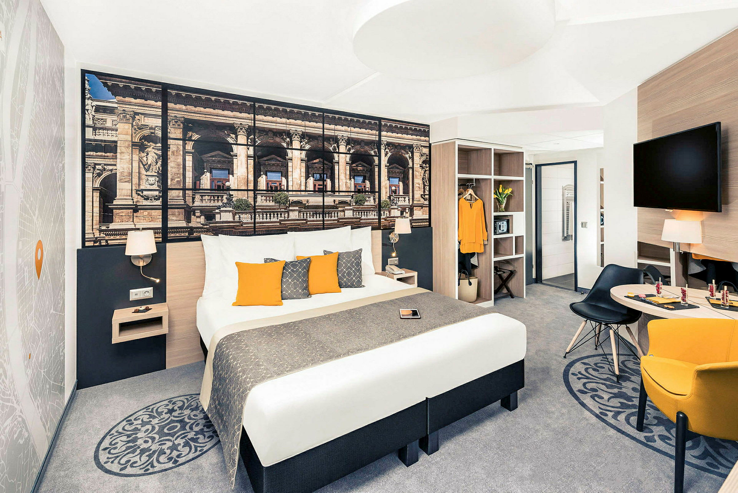 Hotellrum med dubbelsäng, väggdekoration, sittgrupp och garderob. (AI-genererad text)
