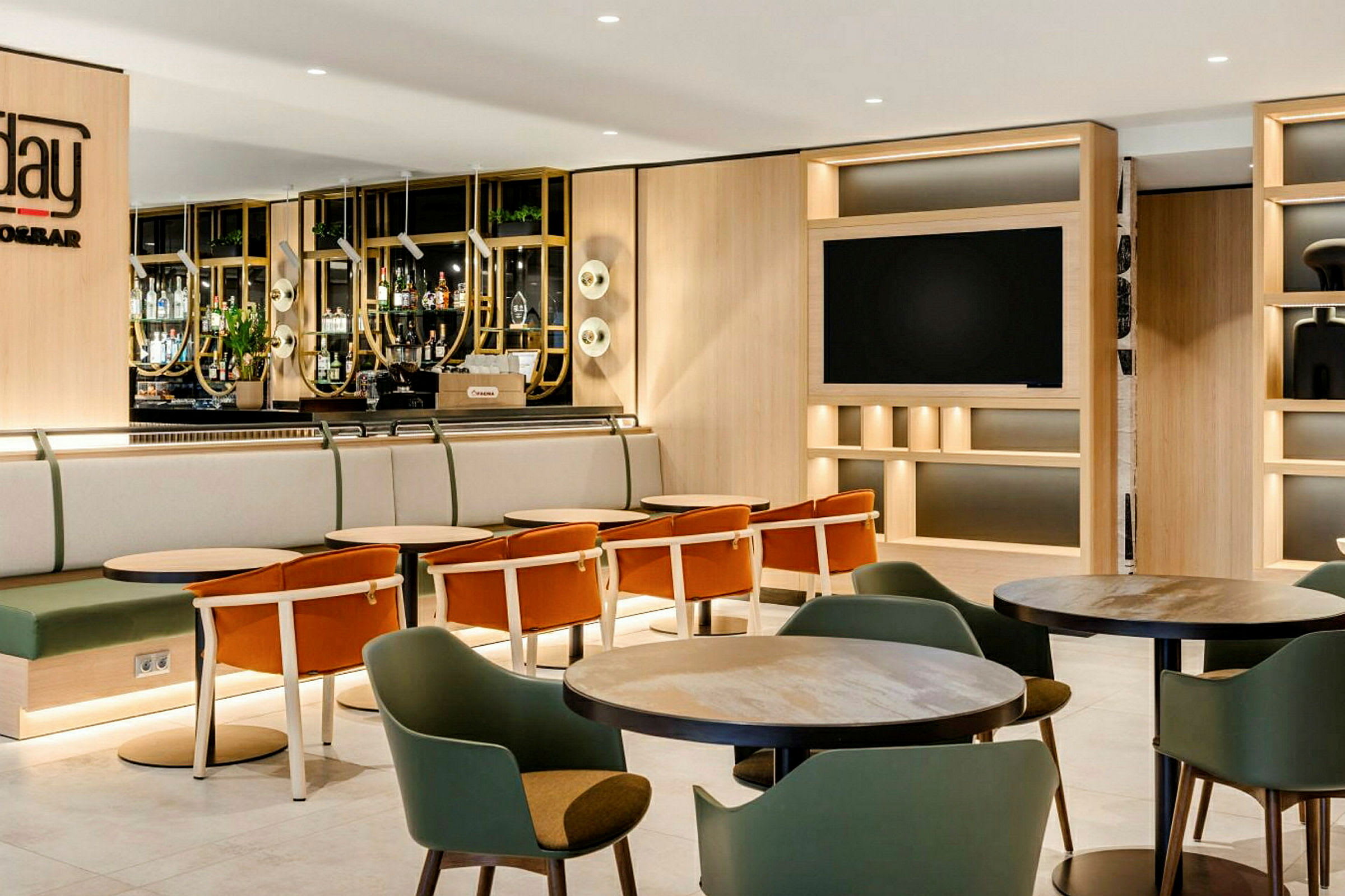 En hotellbar med sittgrupper och bord, omgärdad av en modern och ljus interiördesign. (AI-genererad text)