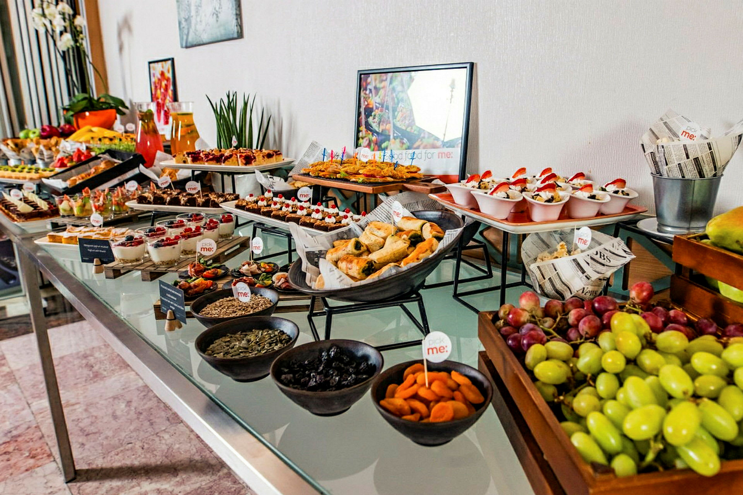 Ett buffébord med olika rätter och snacks, inklusive frukt, bakverk och desserter. (AI-genererad text)