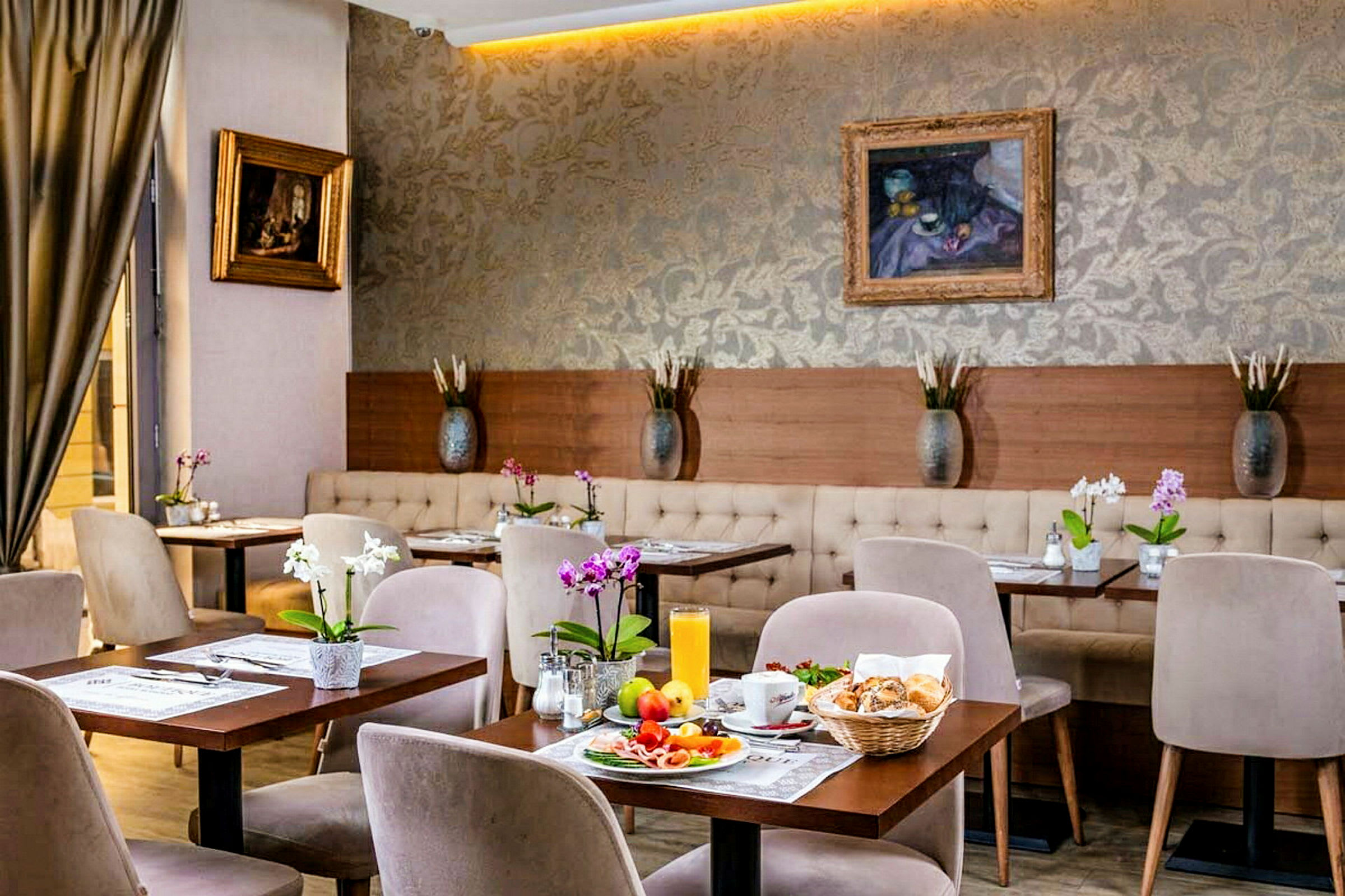 Ett stilrent möblat kafé med små bord, stolar och blommor samt frukost upplagd på ett av borden. (AI-genererad text)