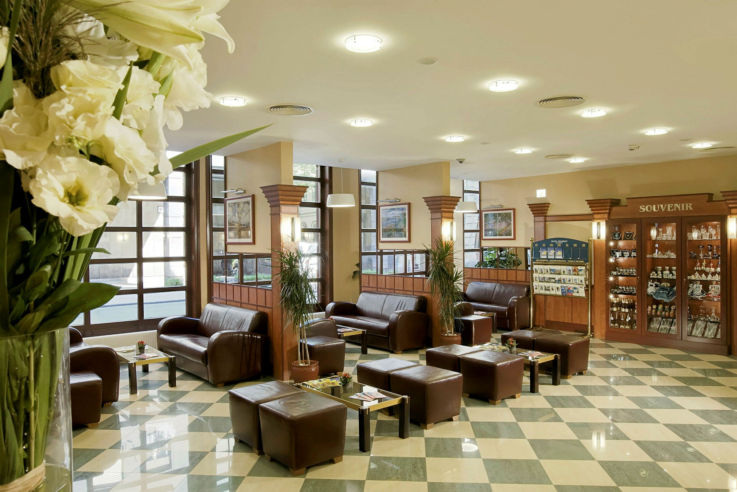 Hotellobby med soffor, bord och souvenirförsäljning. (AI-genererad text)