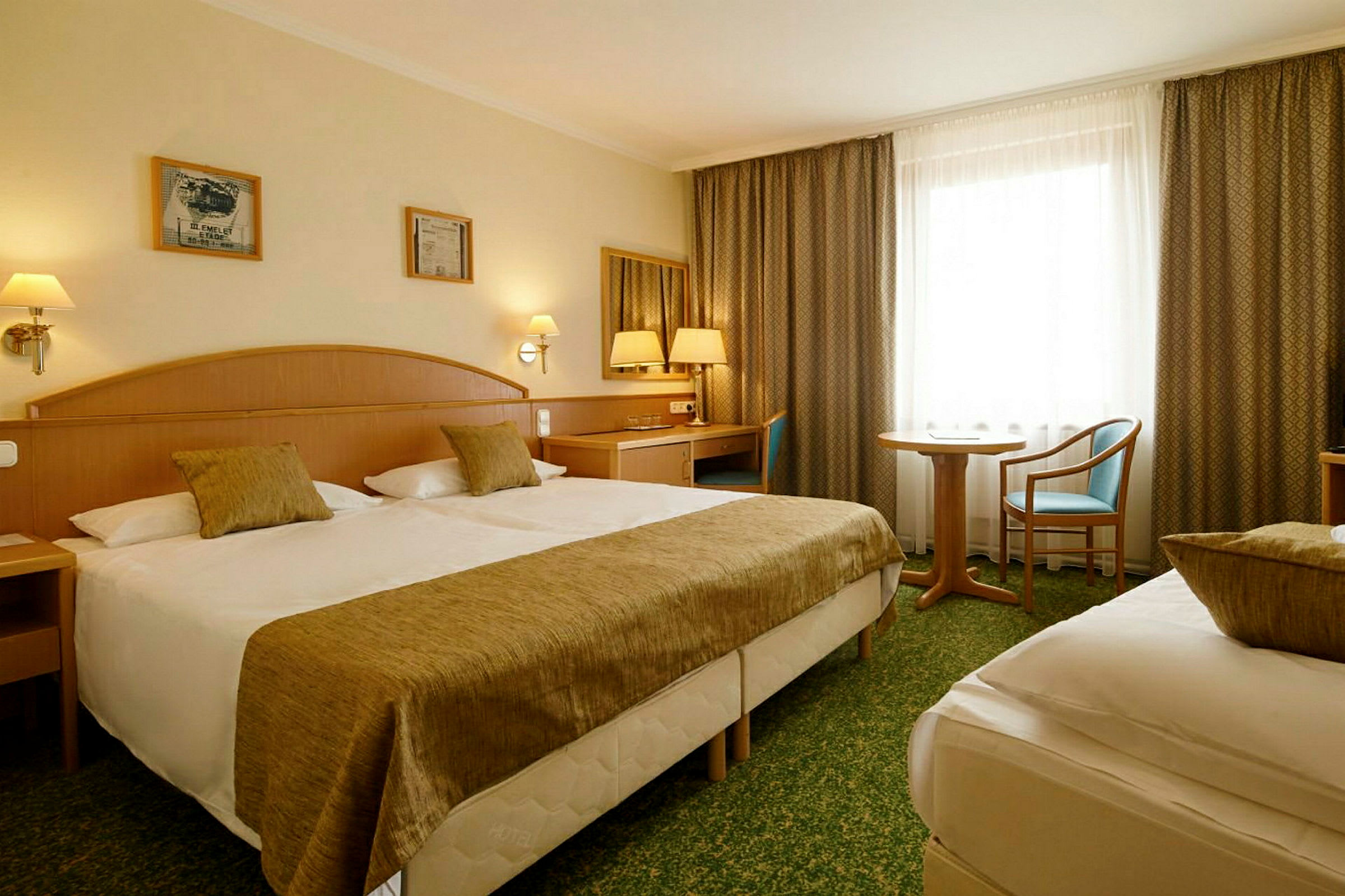 Ett hotellrum med två sängar, skrivbord och sittgrupp. (AI-genererad text)
