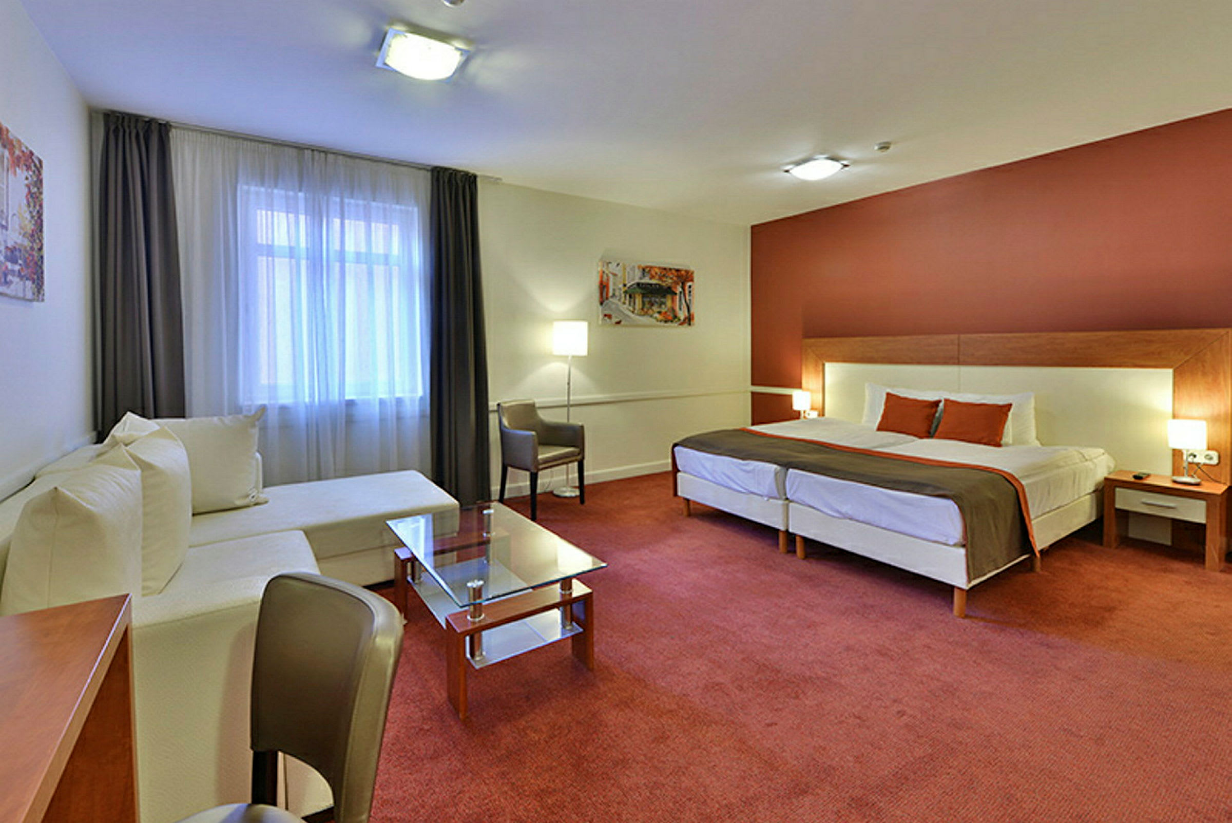 Ett modernt hotellrum med en stor säng, vita möbler och röd matta. (AI-genererad text)
