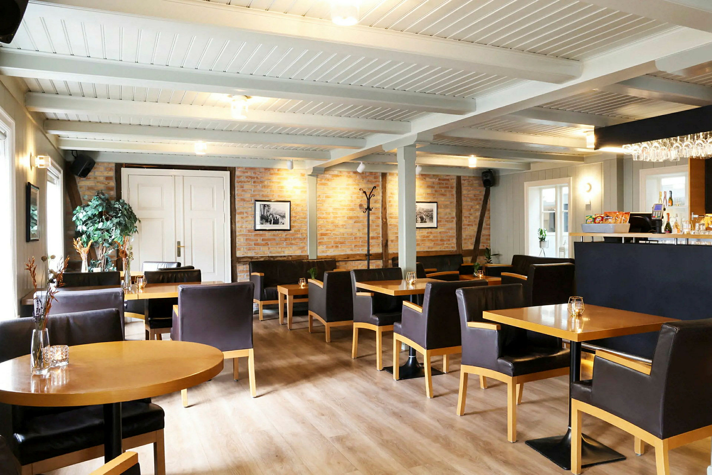 En avbildning av en inomhusrestaurang med bord, stolar och en bar. (AI-genererad text)
