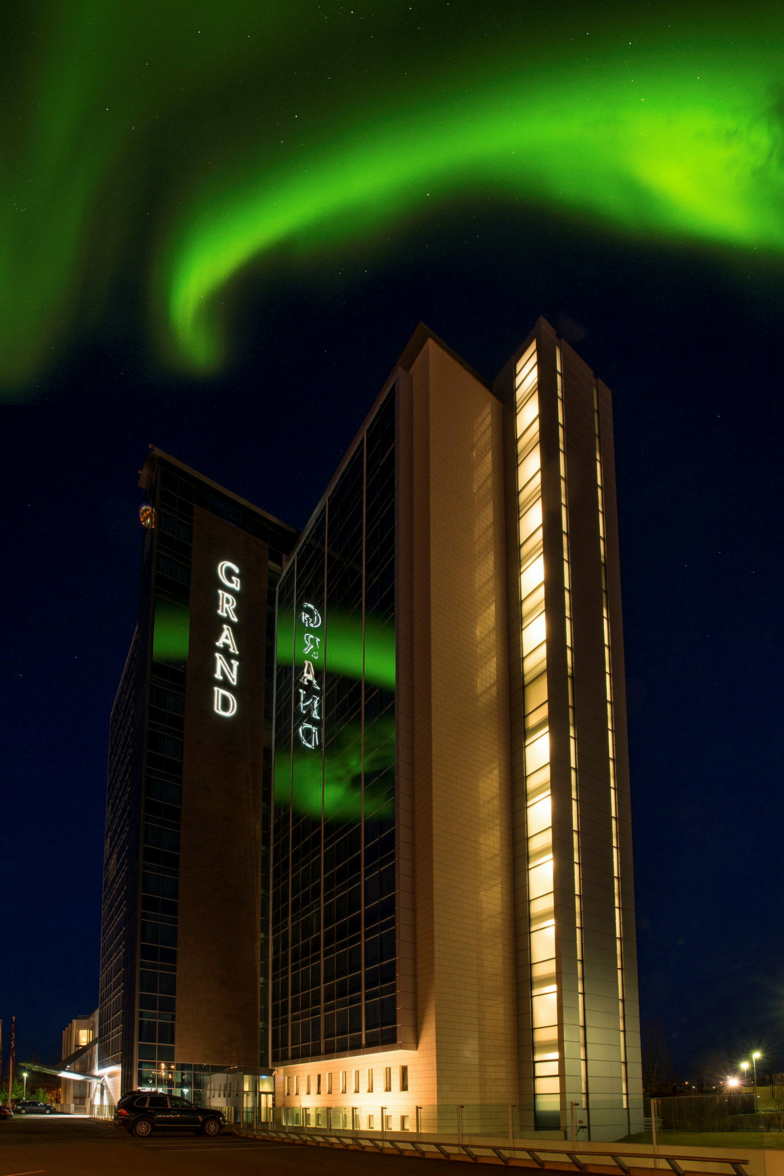 En byggnad under natthimlen med norrsken som sträcker sig över himlen. (AI-genererad text)