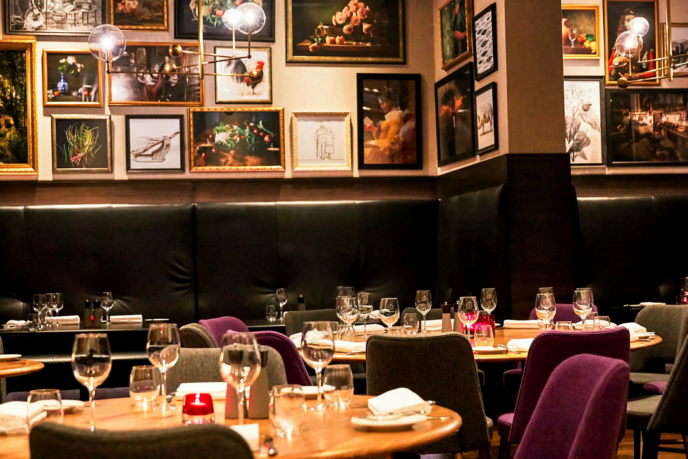 Interiör av en restaurang med dukade bord och konstverk på väggarna. (AI-genererad text)