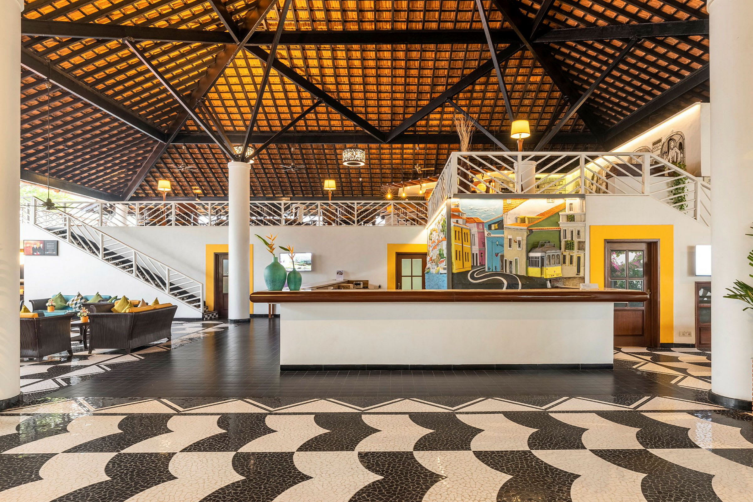 Interiör av en lobby med designat tak, reception och soffgrupp. (AI-genererad text)