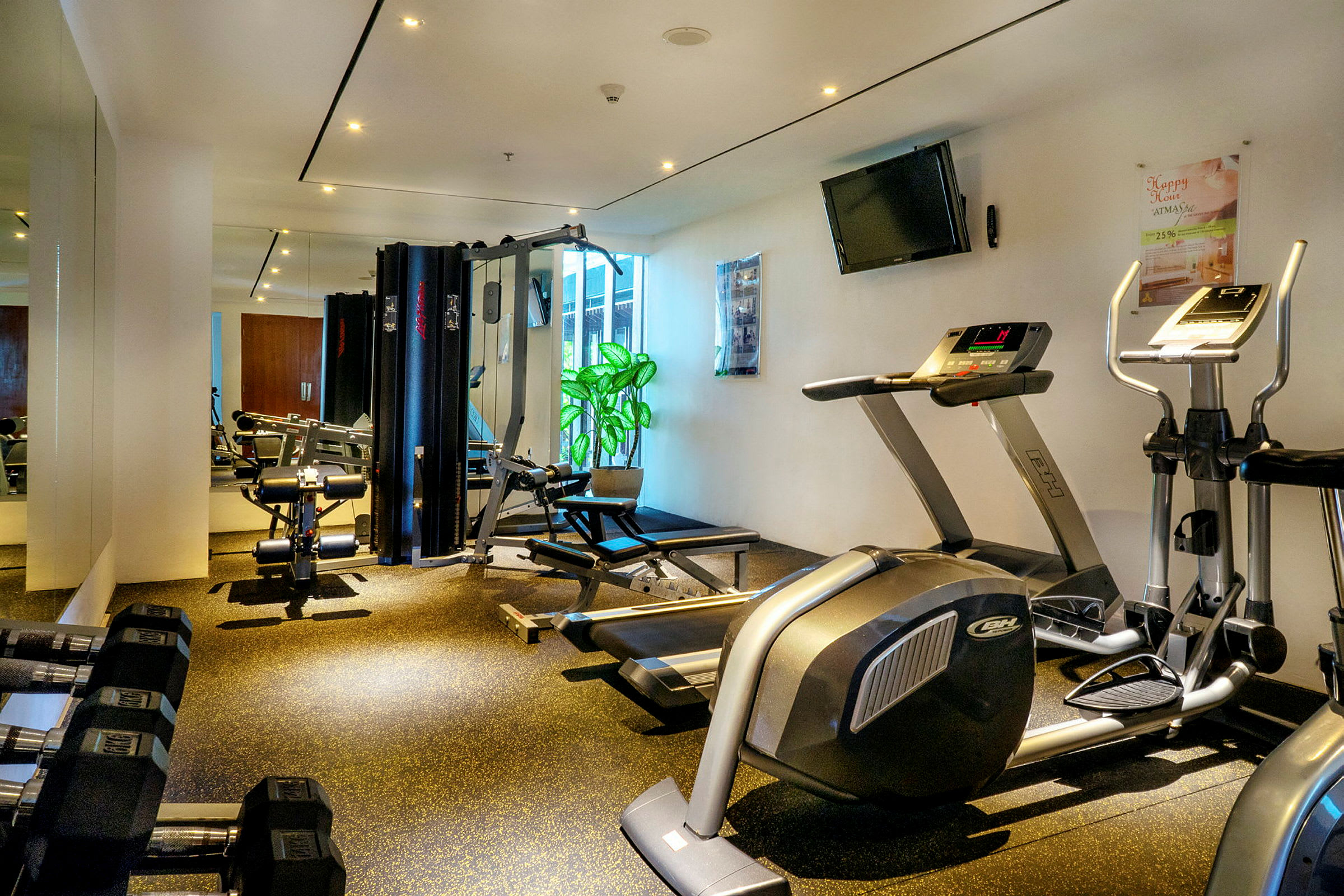 Ett gym med olika träningsmaskiner, vikter och speglar. (AI-genererad text)