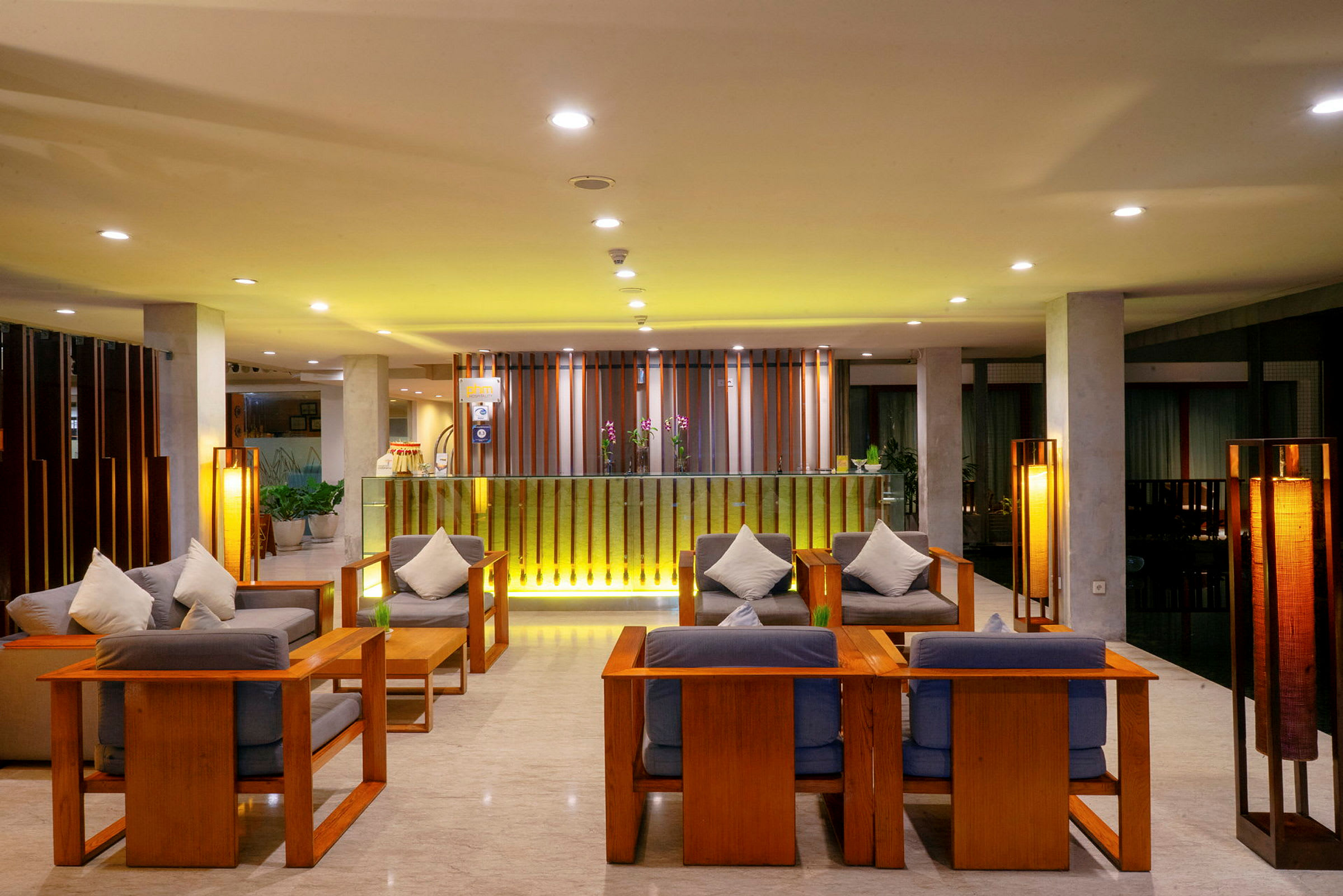 Ett modernt och välbelyst hotellobby med träinredning och bekväma sittplatser. (AI-genererad text)