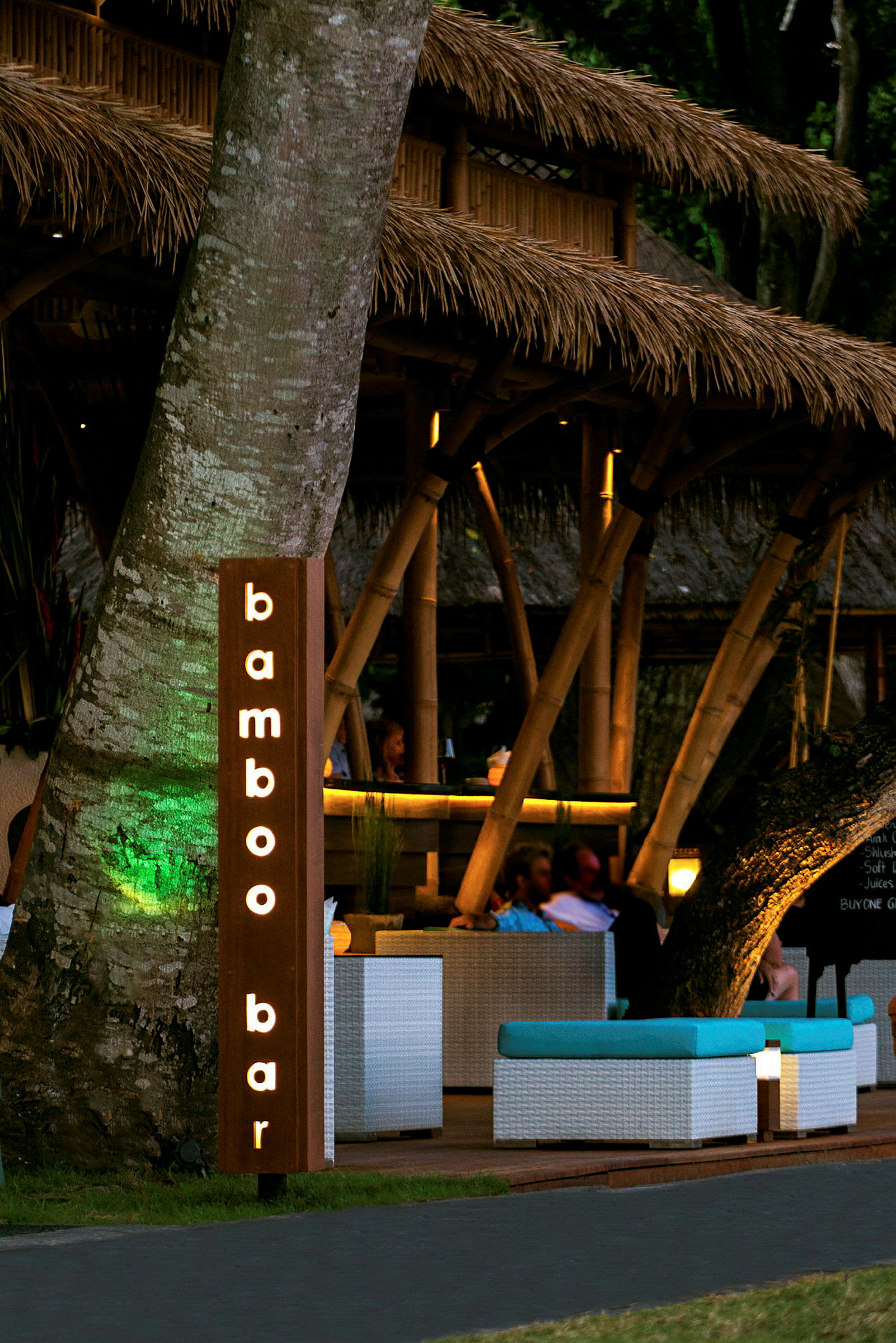 En bar med en skylt som lyder "bamboo bar" och en interiör med bambustruktur och sittgrupper. (AI-genererad text)