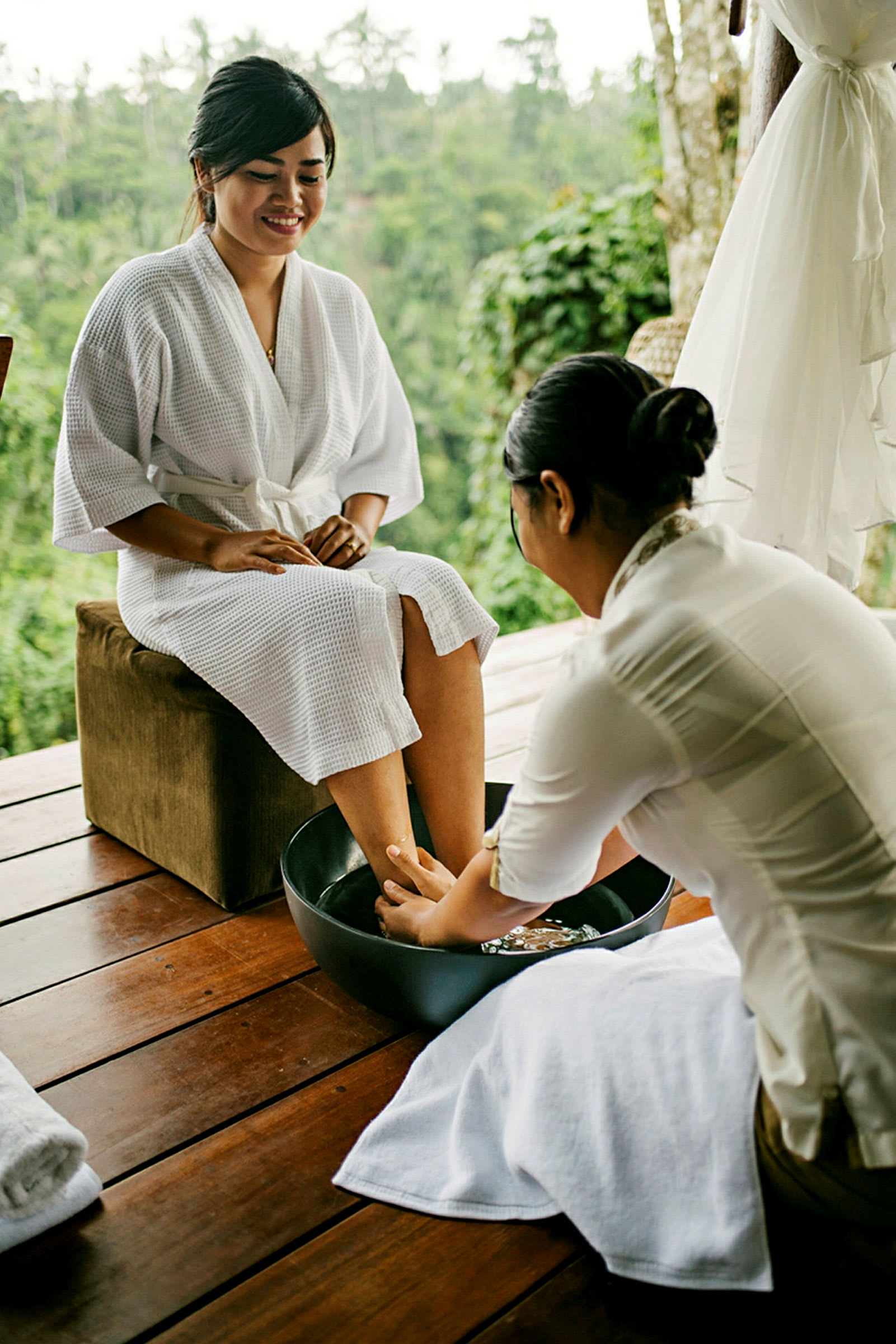 Person som får en fotmassage vid en spa-anläggning med naturen i bakgrunden. (AI-genererad text)