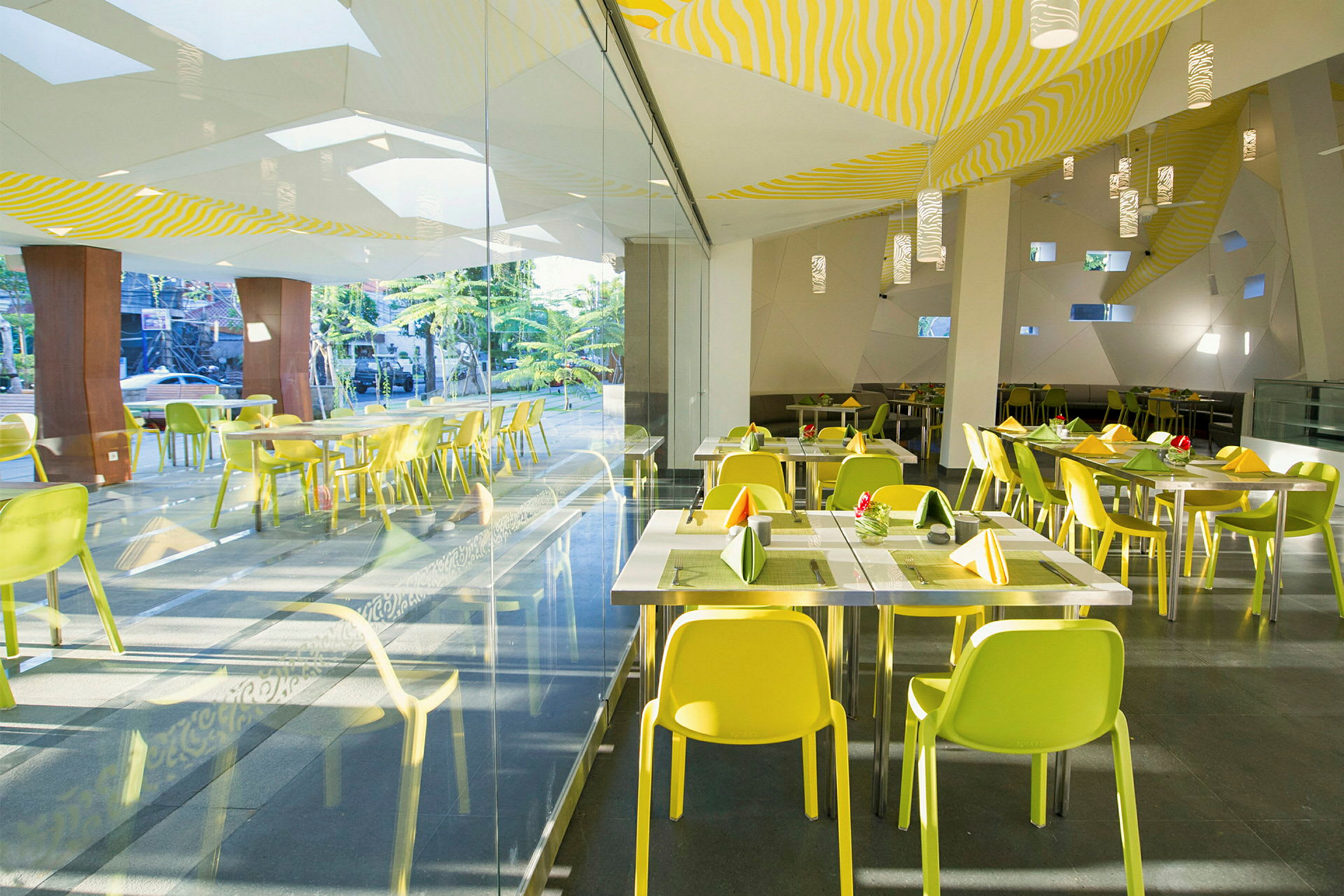 Bild av en modern restaurang med gula stolar och glasväggar. (AI-genererad text)