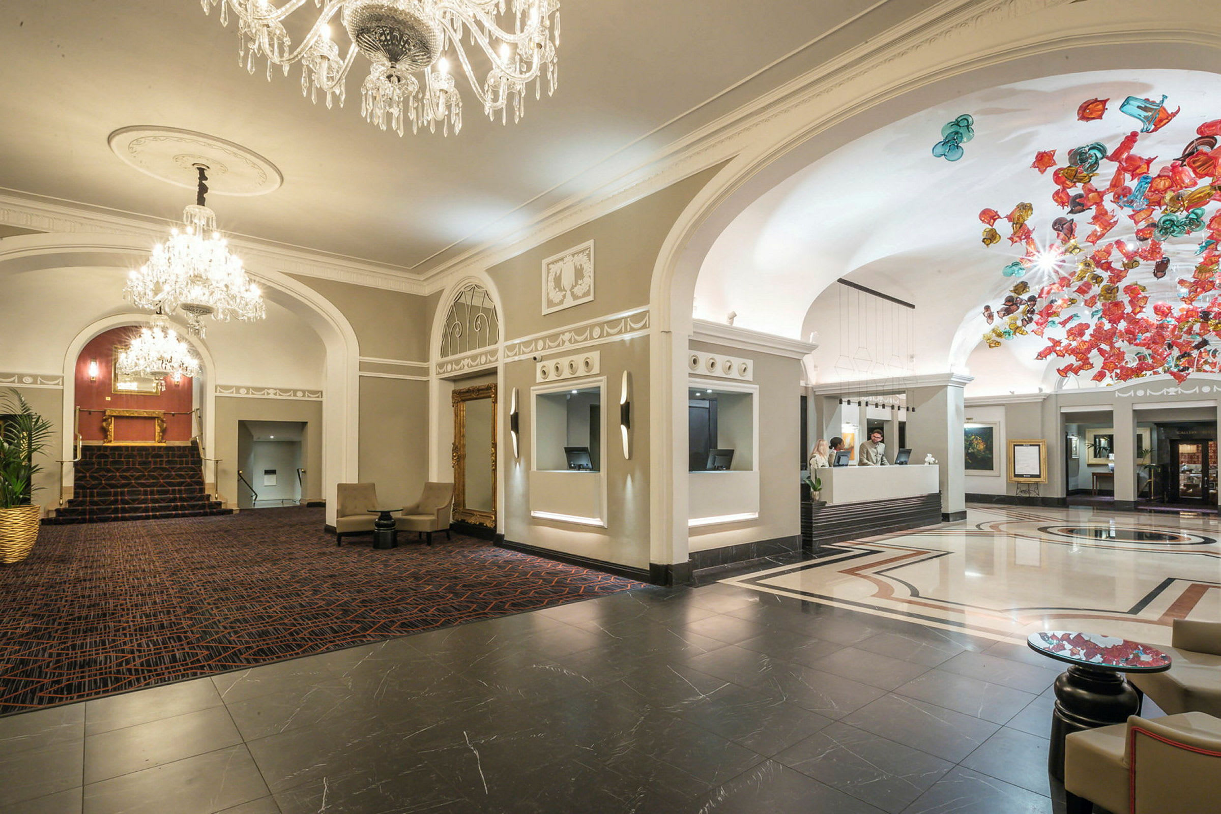Hotellobby med rymd och eleganta detaljer, reception till höger. (AI-genererad text)