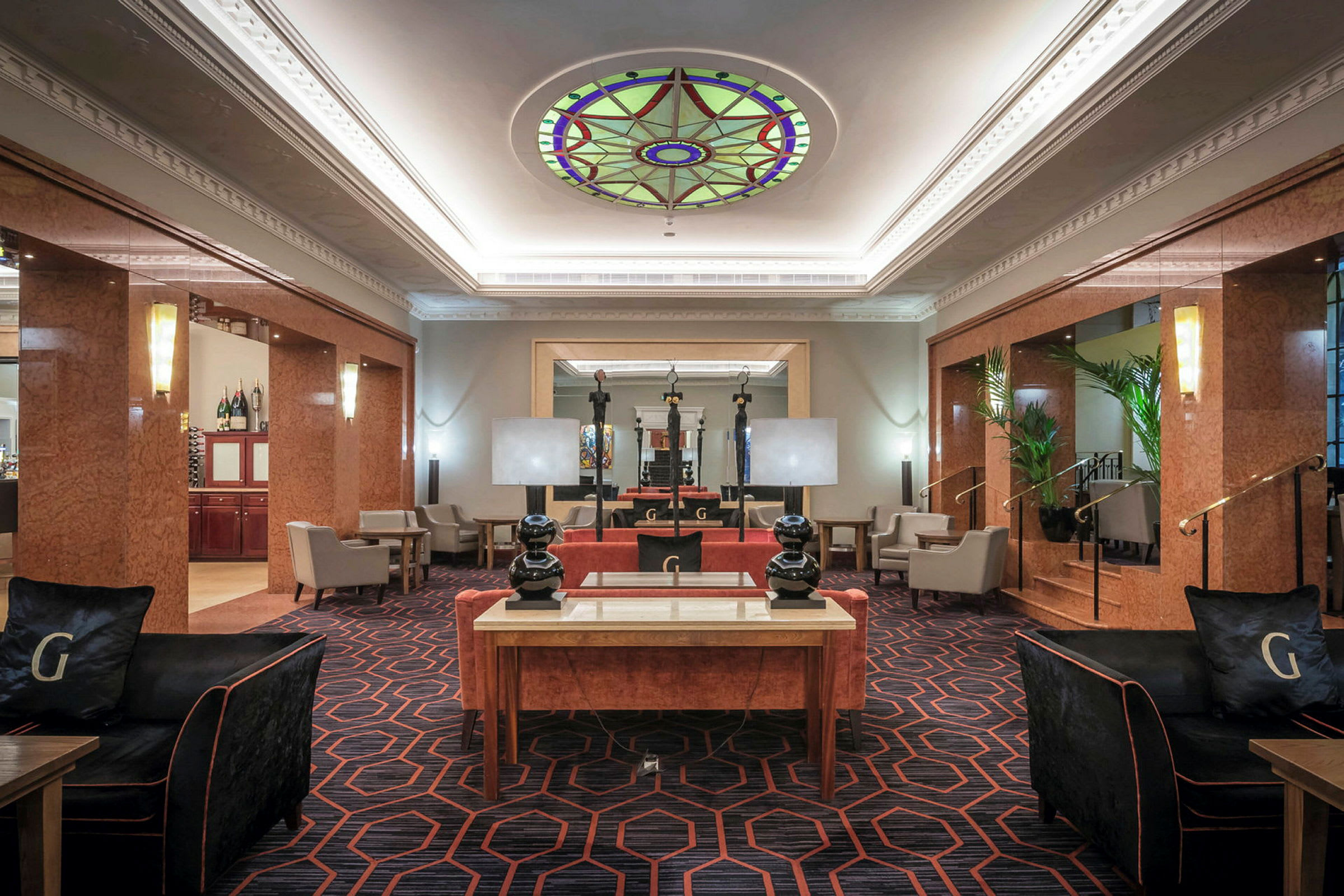 Ett hotellobby med bekväma möbler och dekorativt glastak. (AI-genererad text)