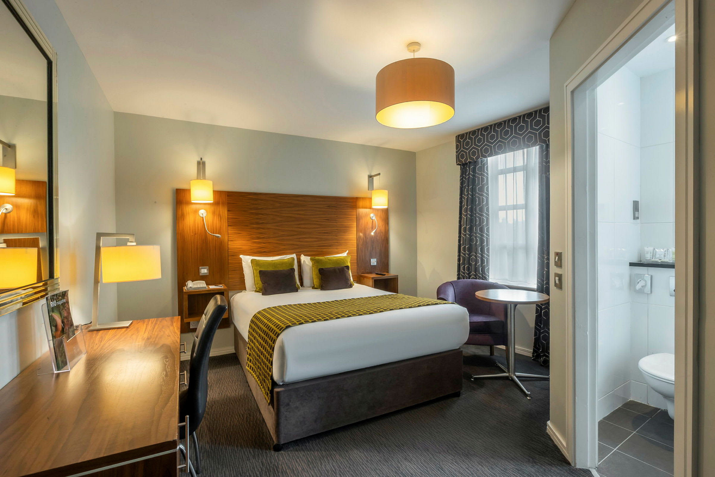 Ett rum med en säng, skrivbord och fönster. (AI-genererad text)