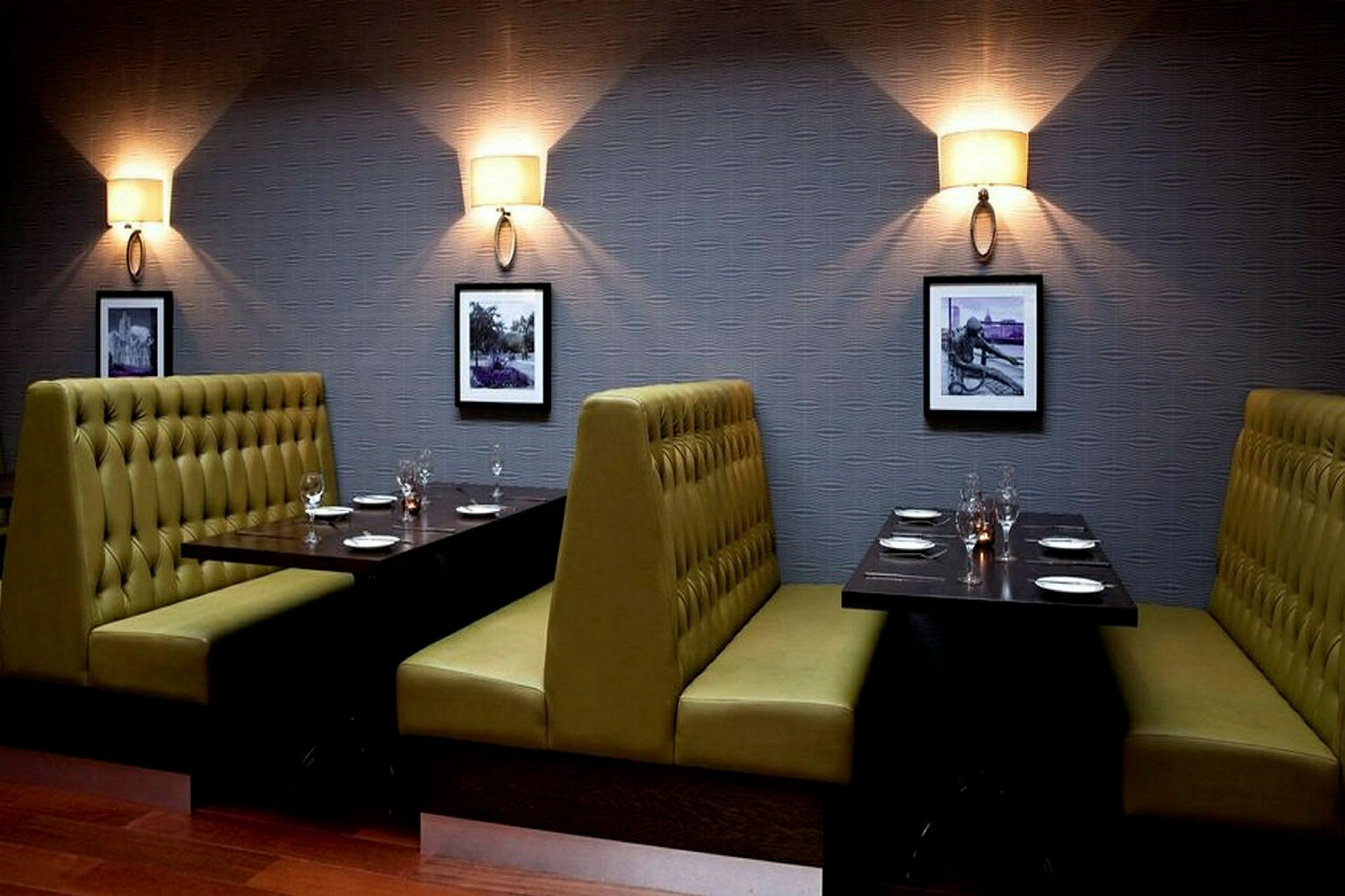 Bild av en restaurang med sittplatser i bås. Väggarna är prydda med små tavlor och vägglampor. (AI-genererad text)