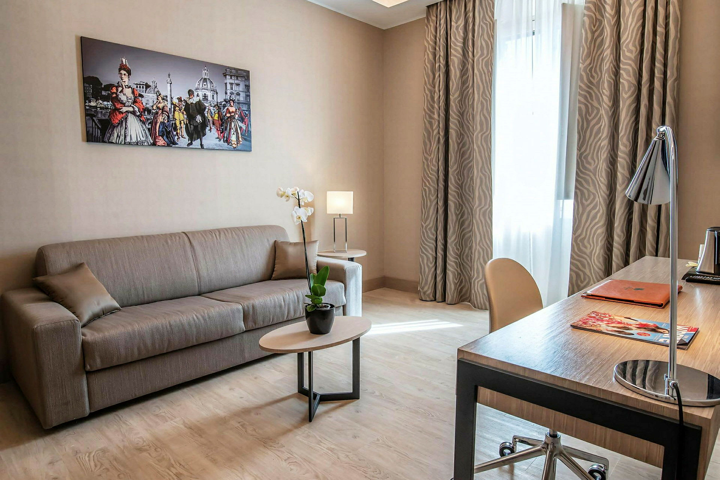 Ett välmöblerat vardagsrum med soffa och skrivbord, inrett med tavlor och växter. (AI-genererad text)