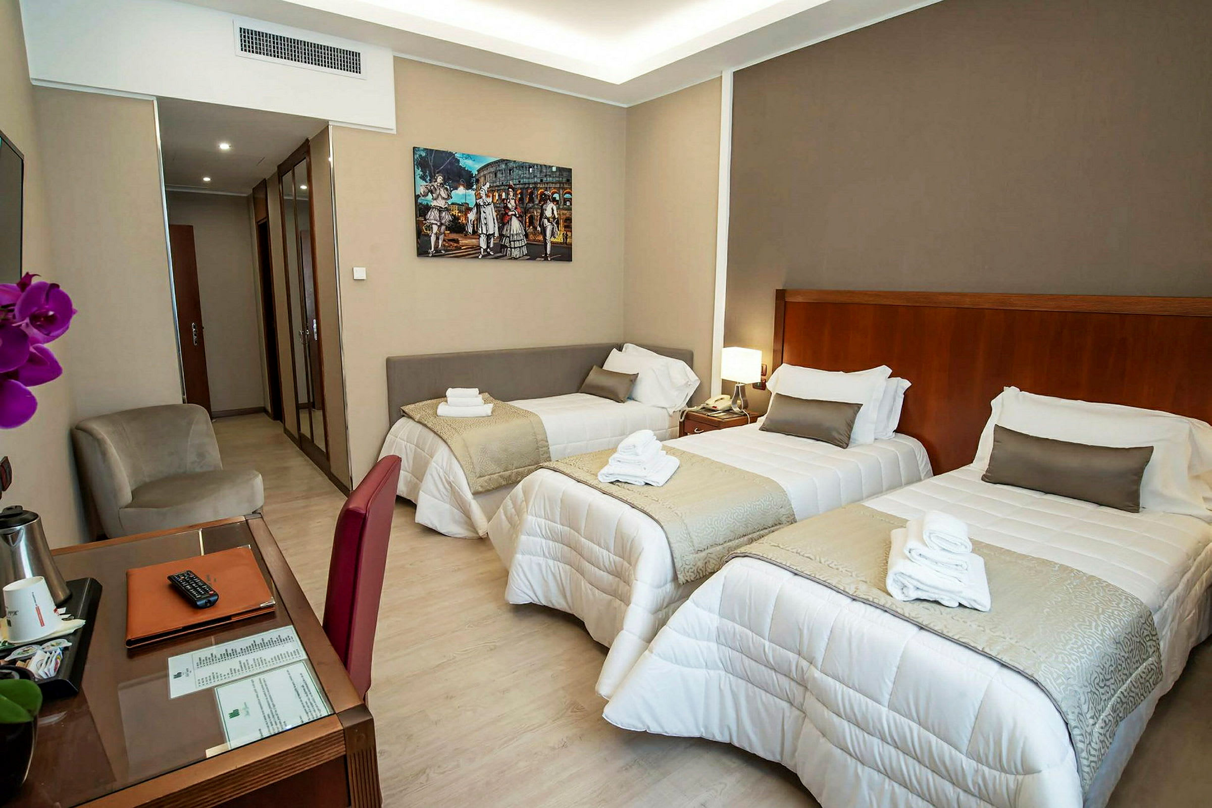 Ett hotellrum med tre enkelsängar och ett skrivbord. (AI-genererad text)