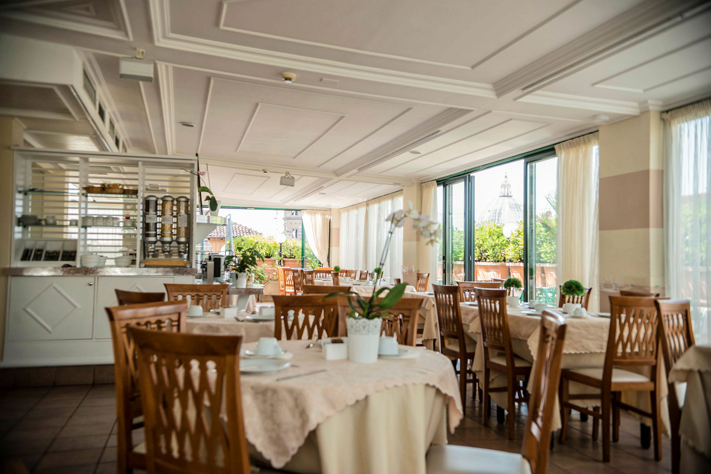En restaurang med dukade bord och utsikt mot en byggnad med kupol. (AI-genererad text)