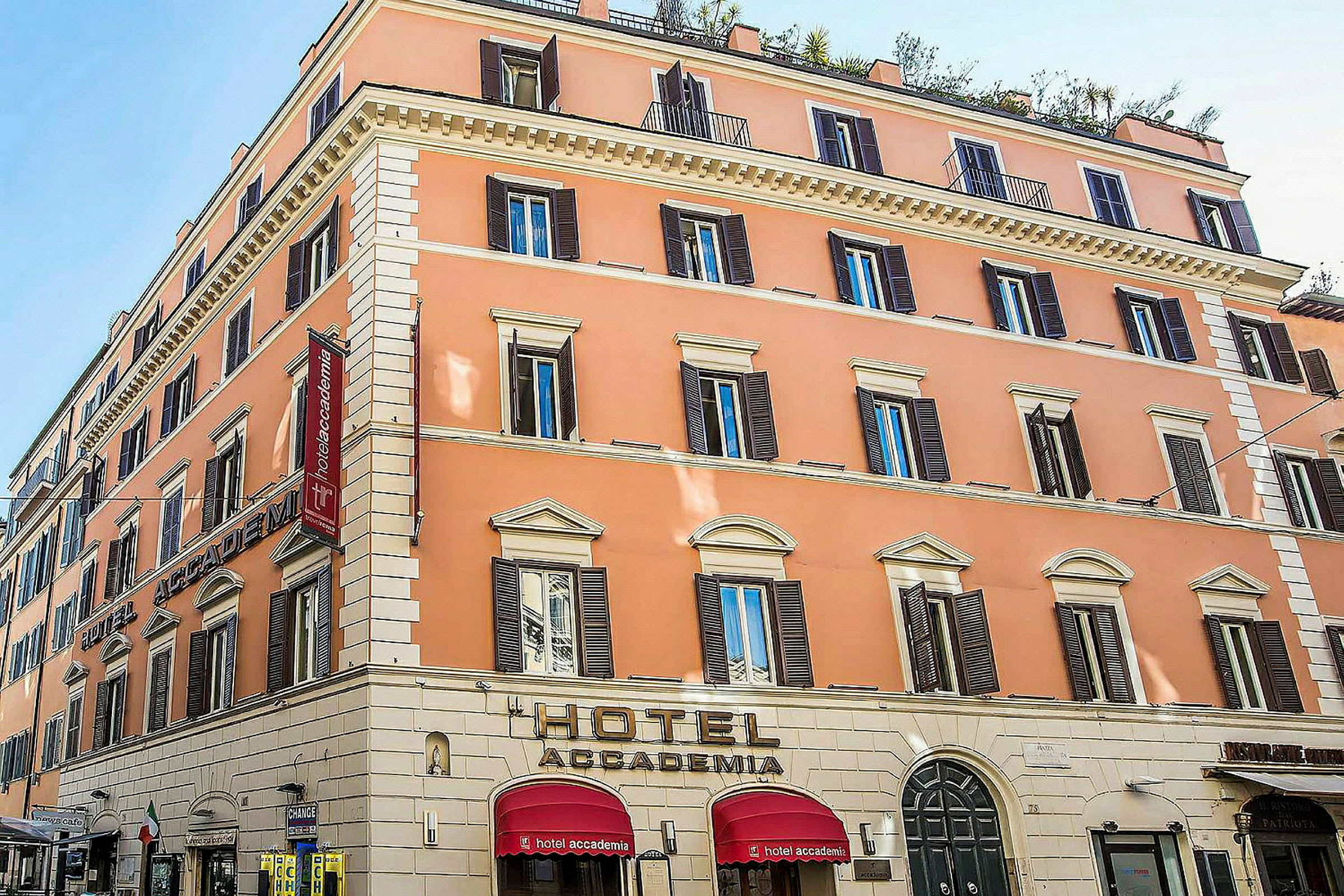Ett hotell i en pastellfärgad byggnad med flera våningar och många fönster. (AI-genererad text)