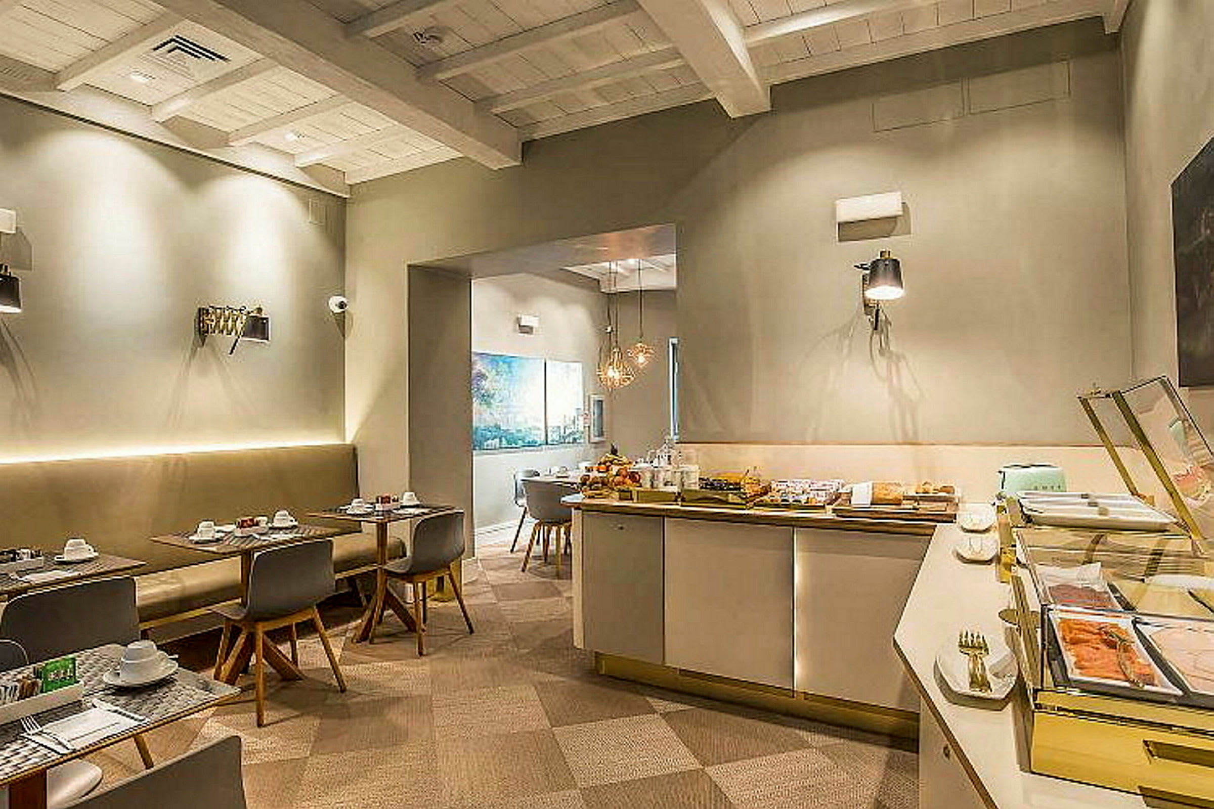Ett rum i en restaurang eller hotell med dukade matbord och en frukostbuffé. (AI-genererad text)