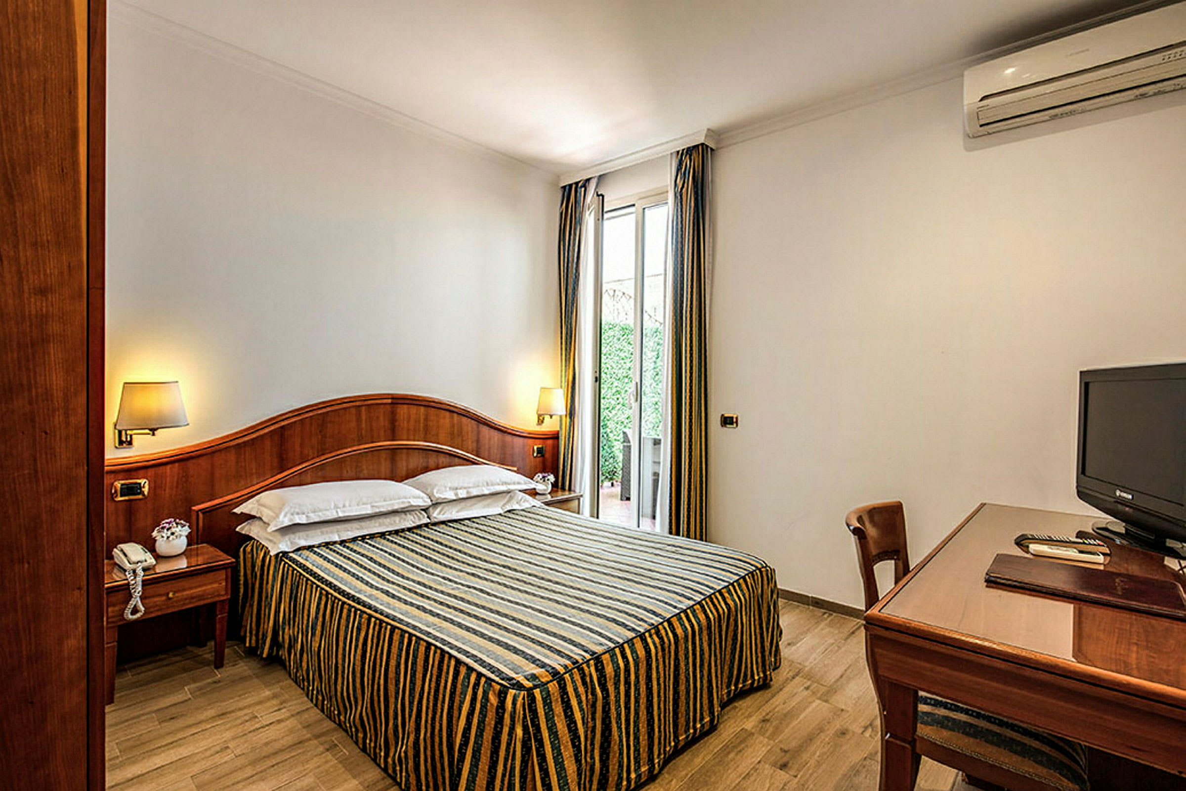 Ett hotellrum med en dubbelsäng, ett skrivbord och en TV. (AI-genererad text)