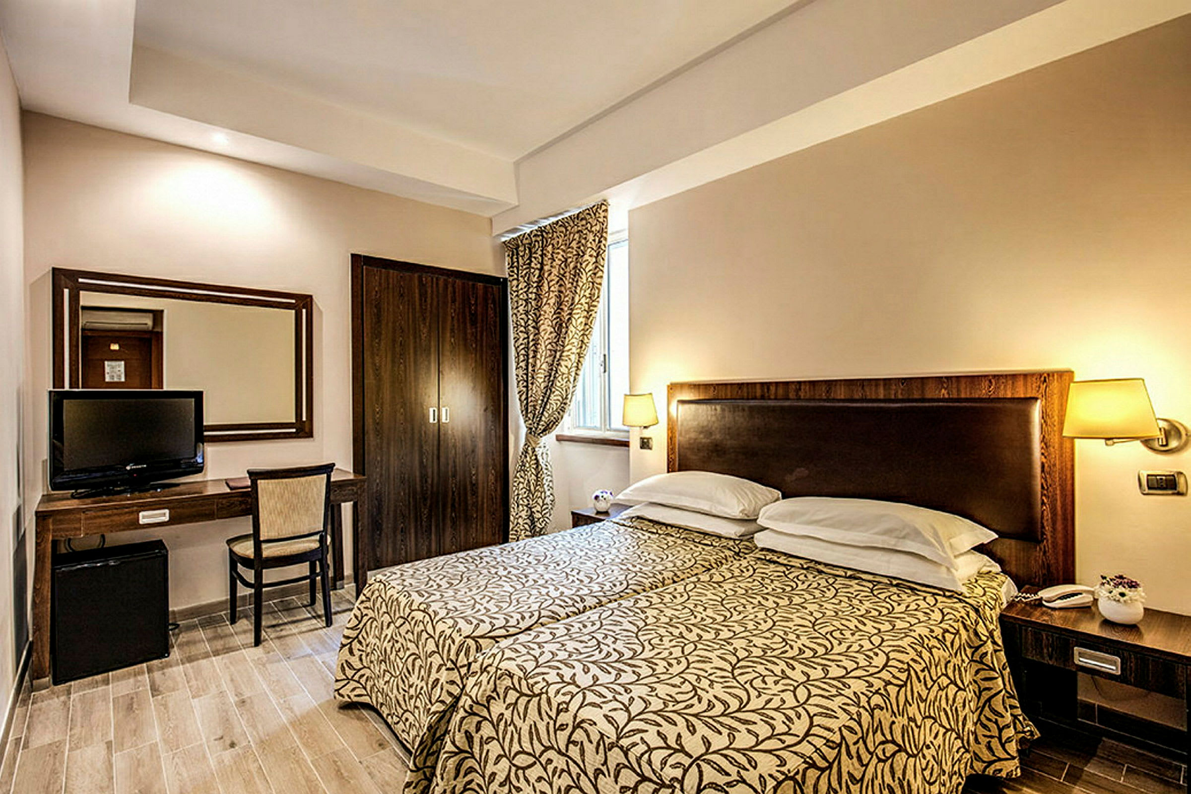 Ett hotellrum med två enkelsängar, ett skrivbord och en TV. (AI-genererad text)