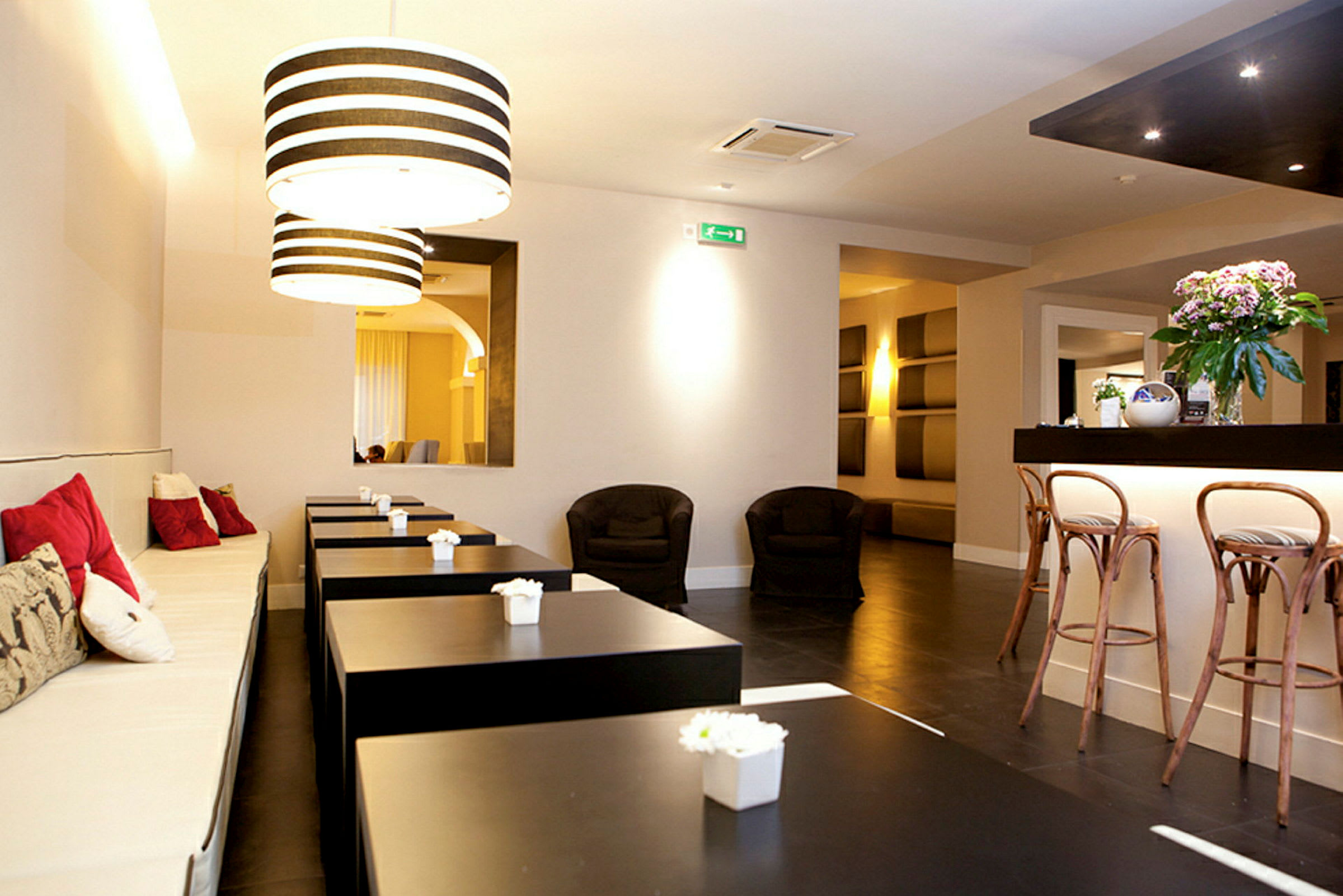 Ett modernt café med sittplatser och dekorativa lampor. (AI-genererad text)