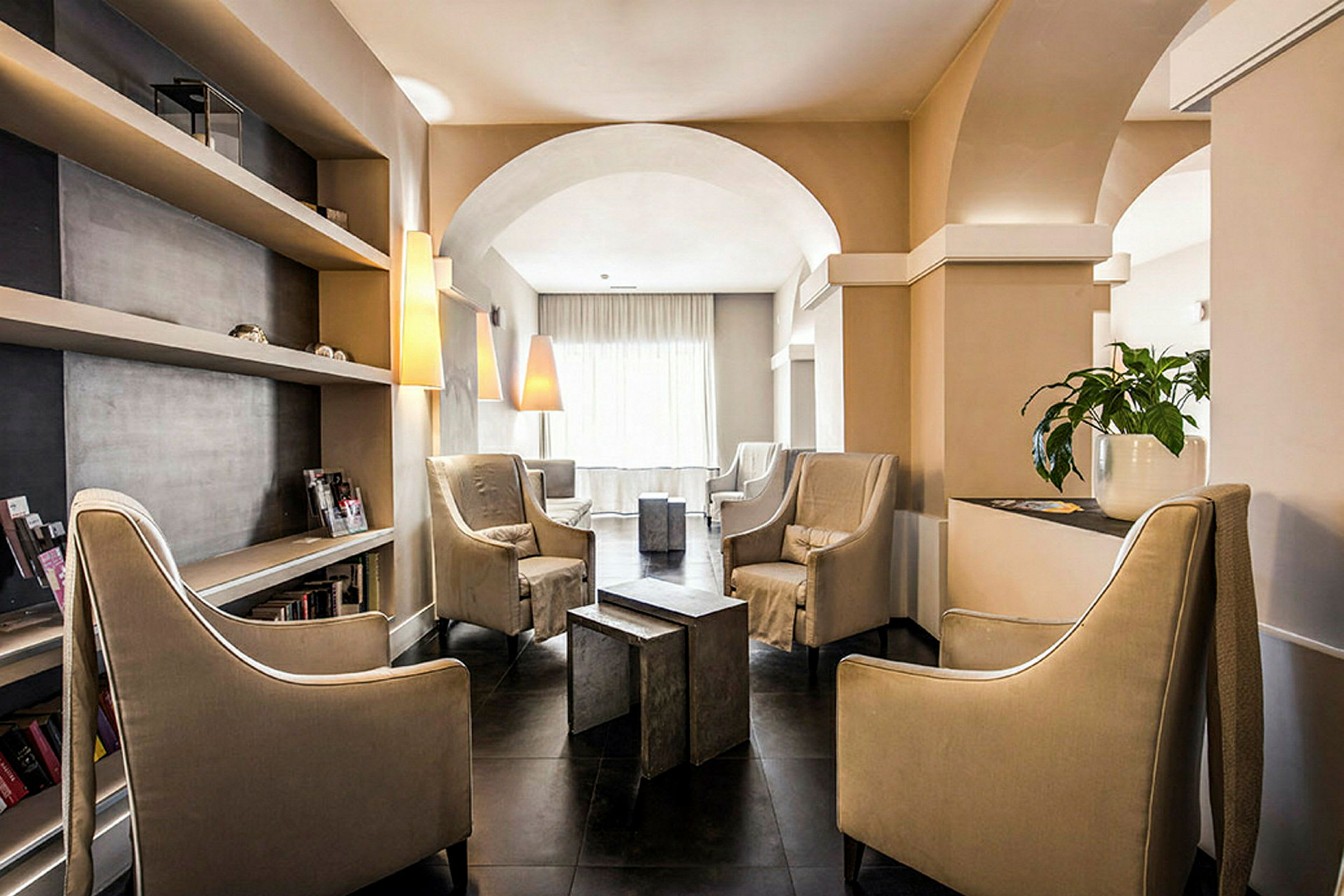 En elegant lounge med stora stolar, hyllor och lampor. (AI-genererad text)