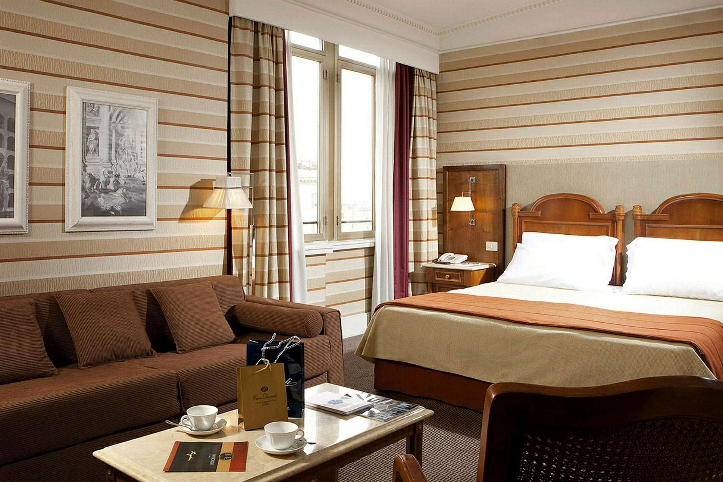 Hotellrum med dubbelsäng, soffa och bord. (AI-genererad text)
