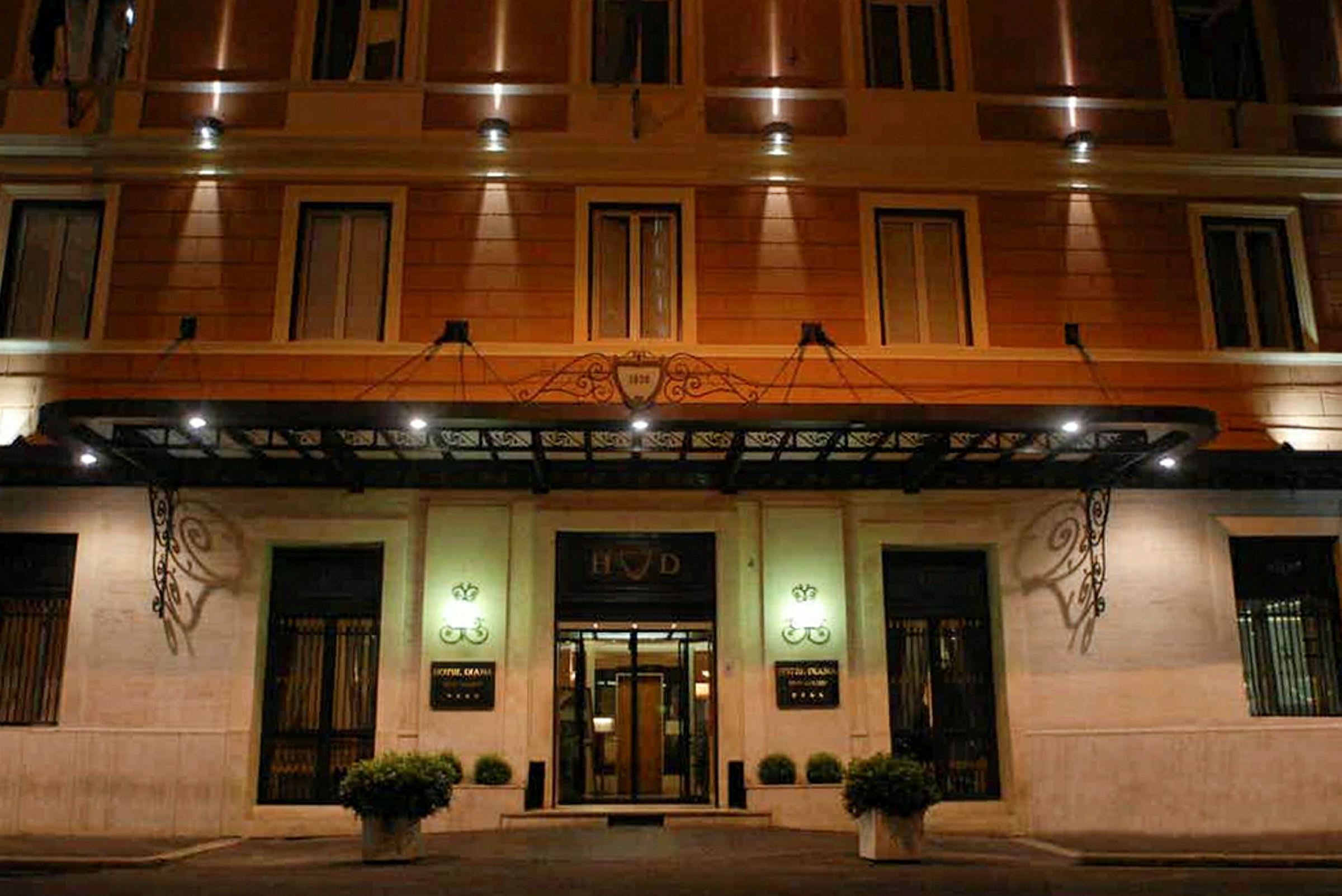 Entrén till ett hotell med belysning och en dekorativ baldakin. (AI-genererad text)