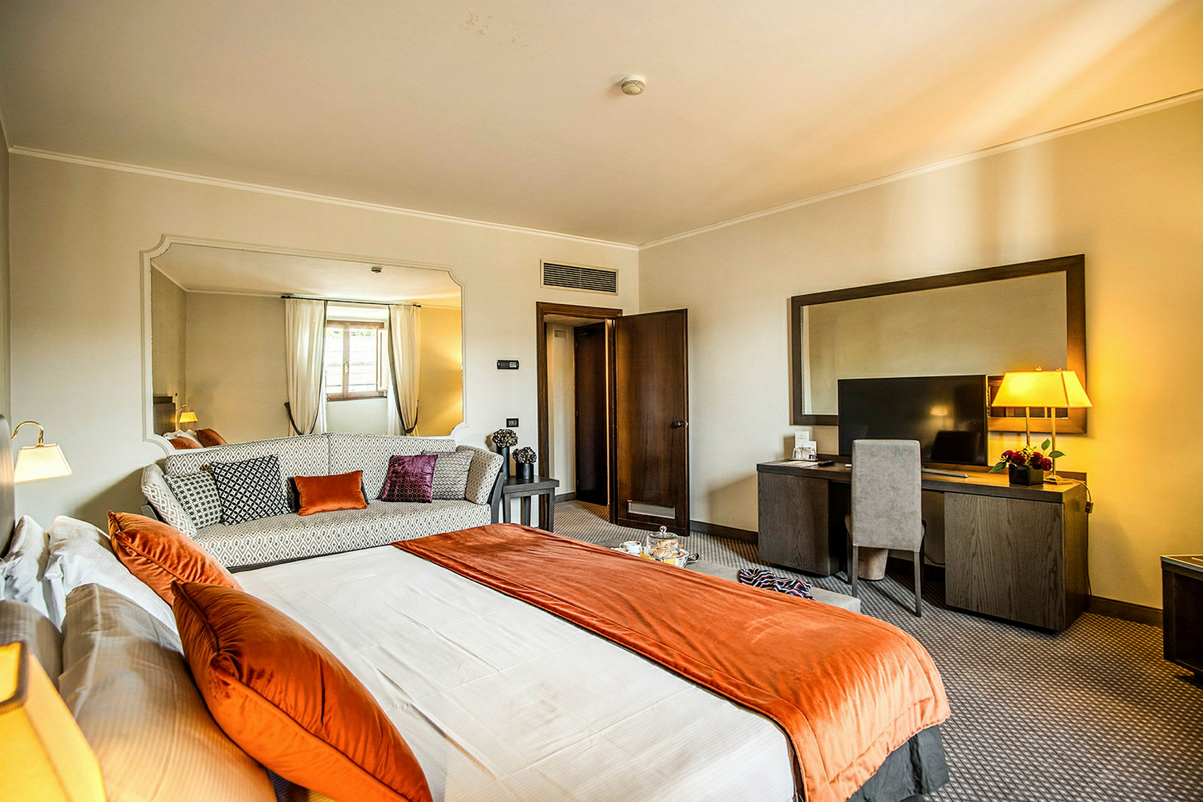 Ett hotellrum med en säng, soffa och skrivbord. (AI-genererad text)