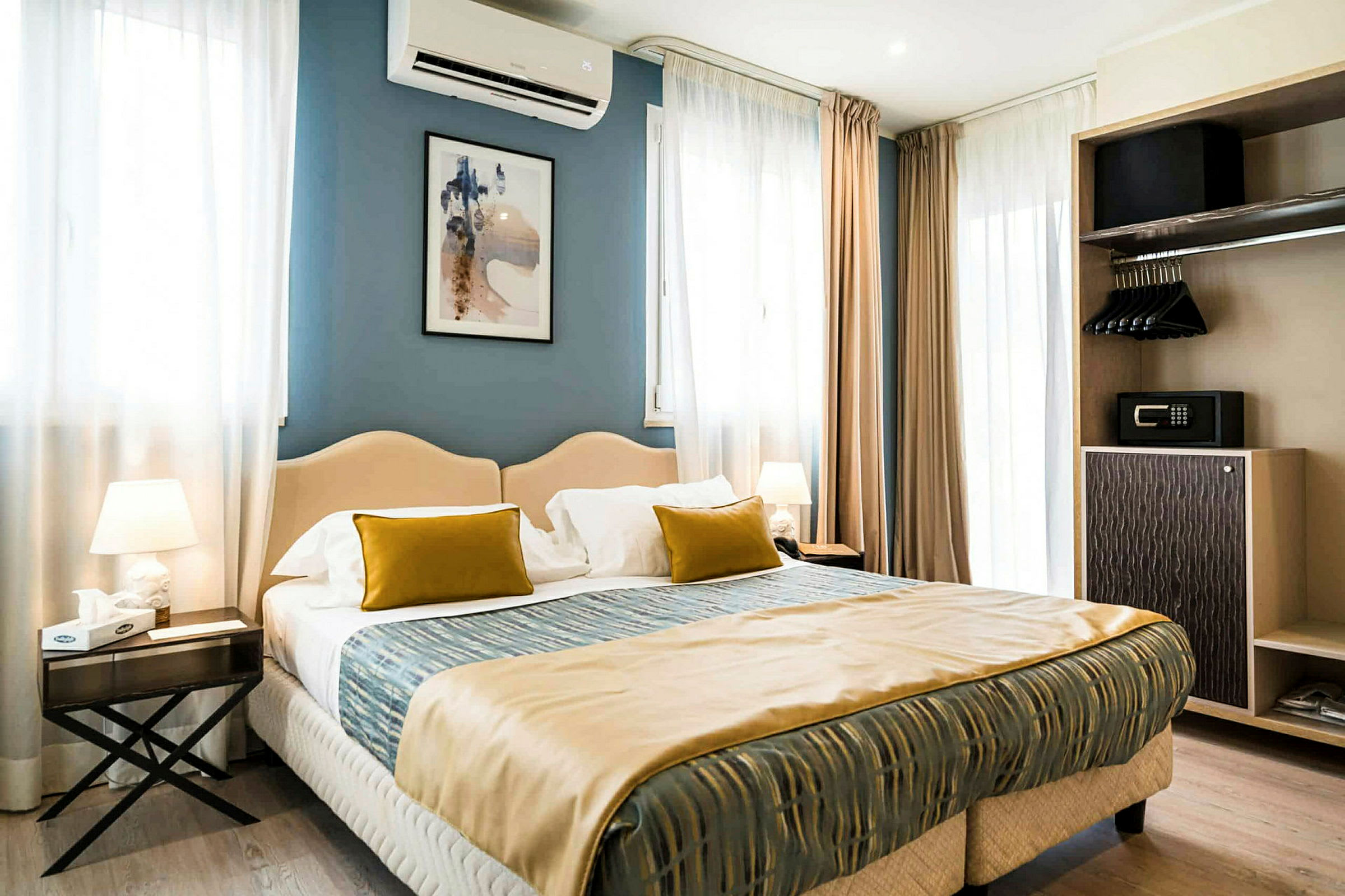 Ett modernt inrett hotellrum med en dubbelsäng, sänglampor, och en öppen garderob. (AI-genererad text)