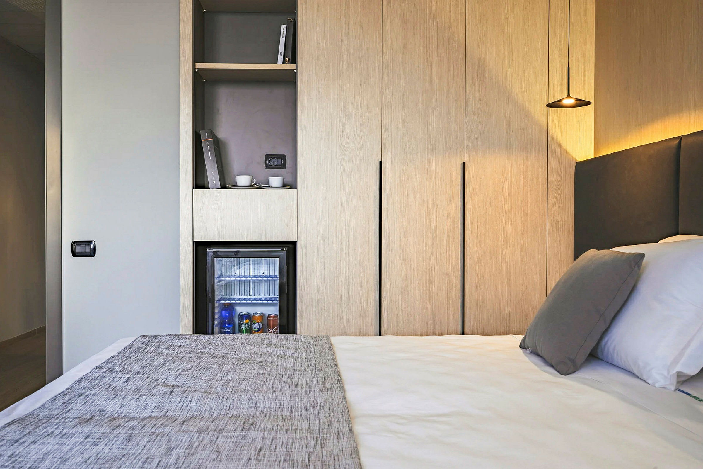 Hotellrum med säng, minibar och garderober. (AI-genererad text)