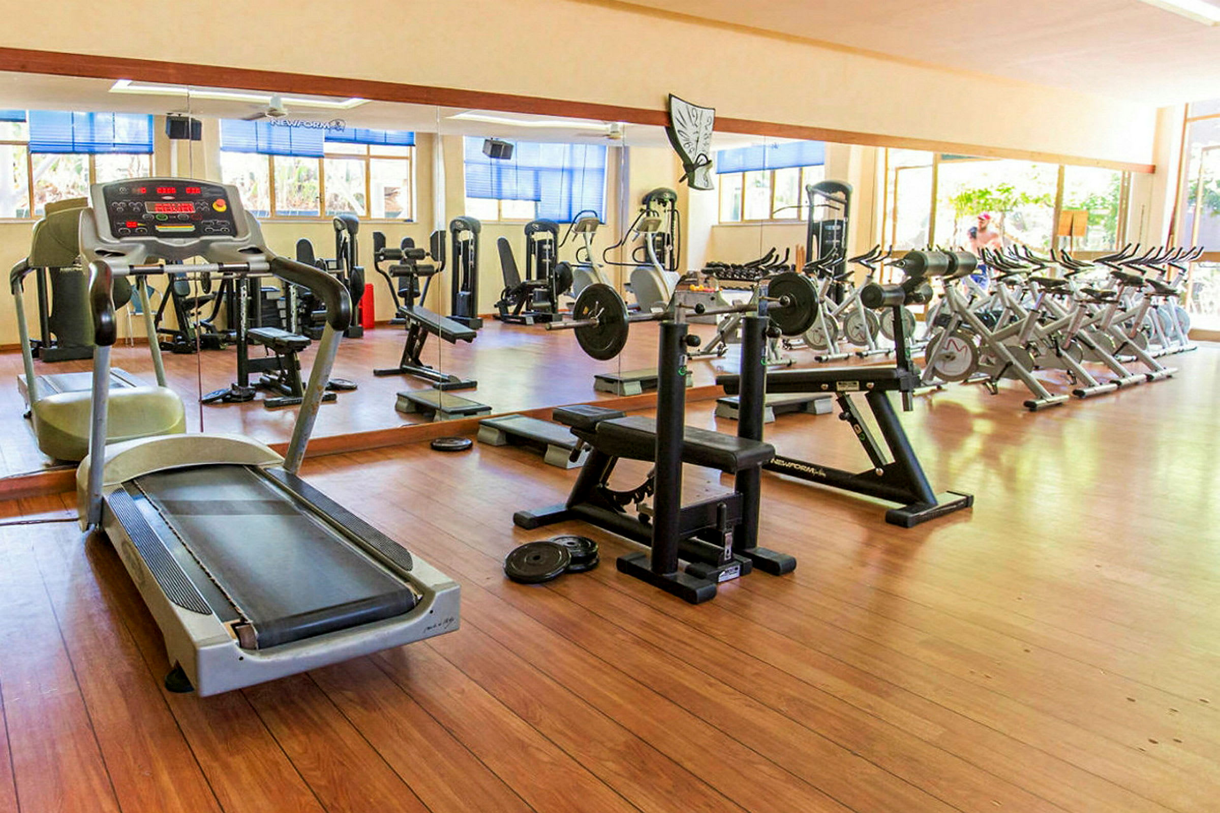 Interiörbild av ett gym med olika träningsmaskiner och redskap. (AI-genererad text)
