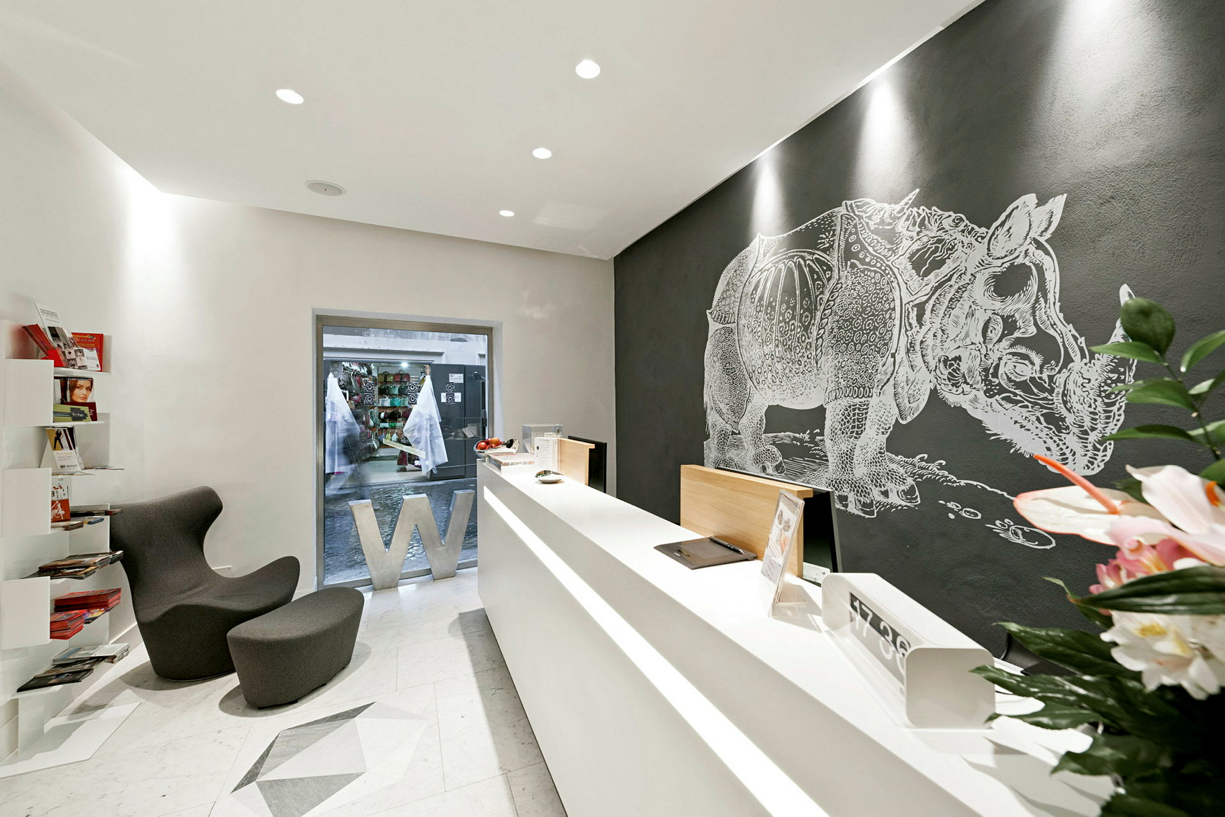 Ett modernt kontor med en minimalistisk design, reception och en väggmålning av en noshörning. (AI-genererad text)