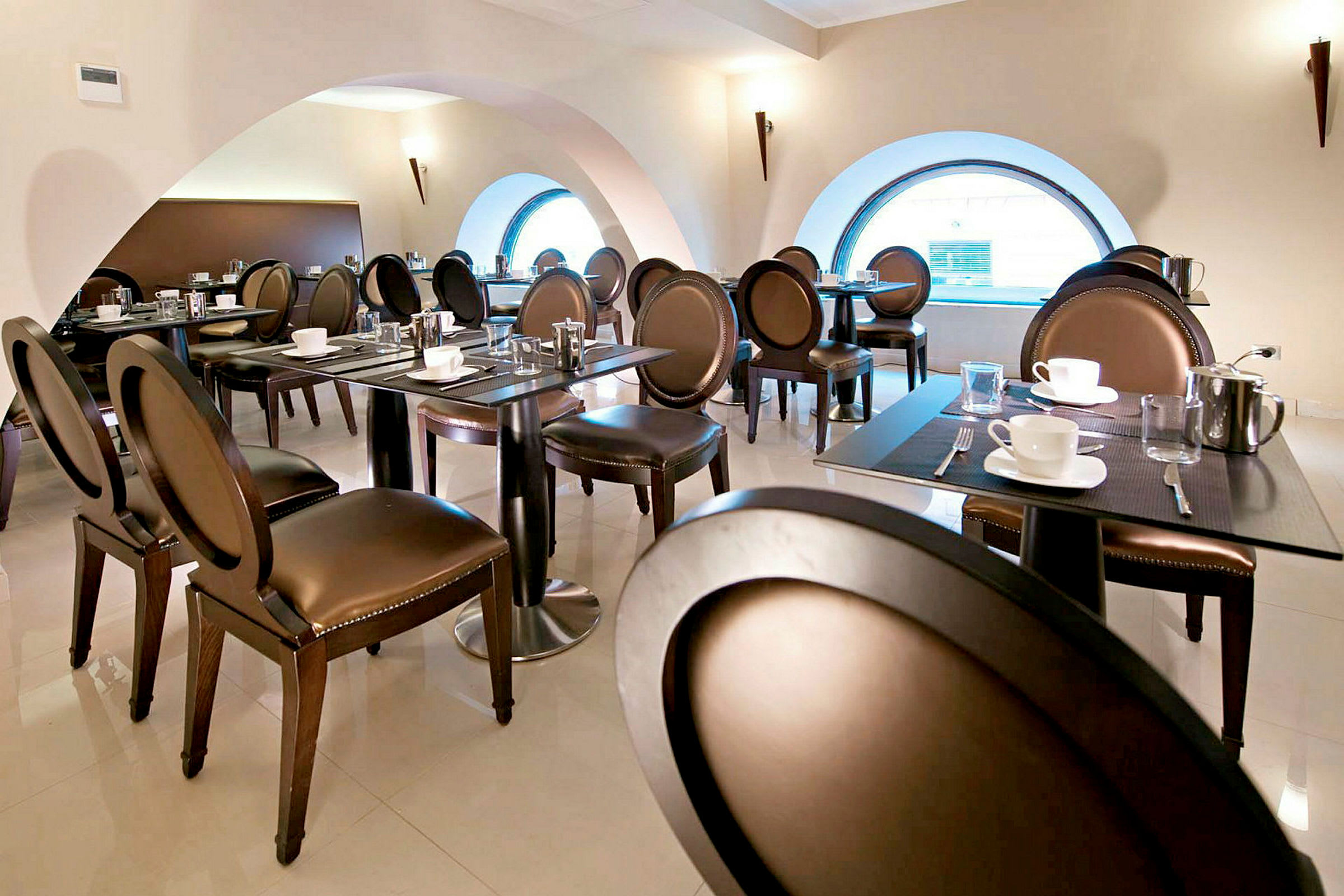 Restaurang med stilrena möbler och dukade bord. (AI-genererad text)