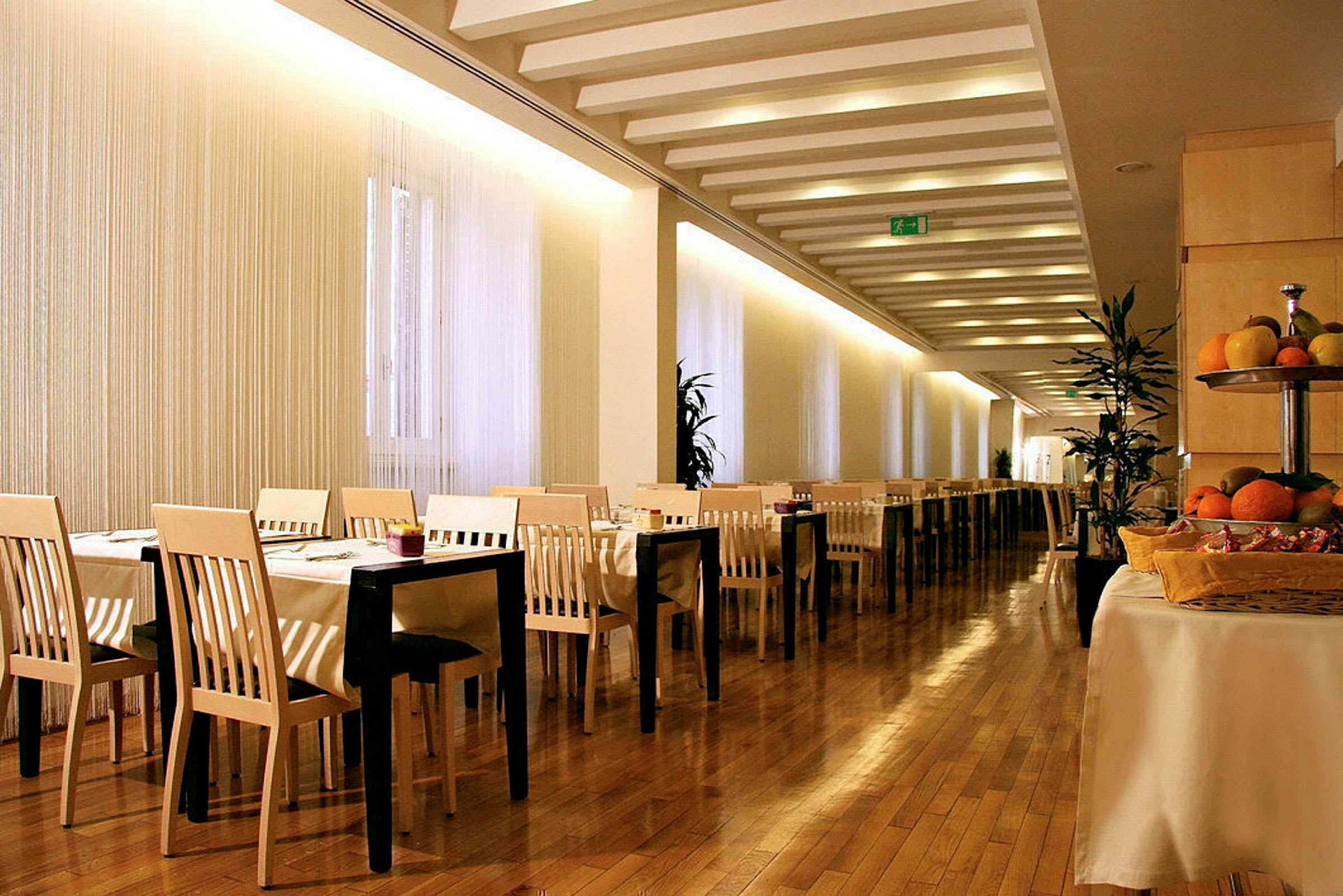 Bild av en restaurang med bord och stolar, trägolv och frukt på ett bord. (AI-genererad text)