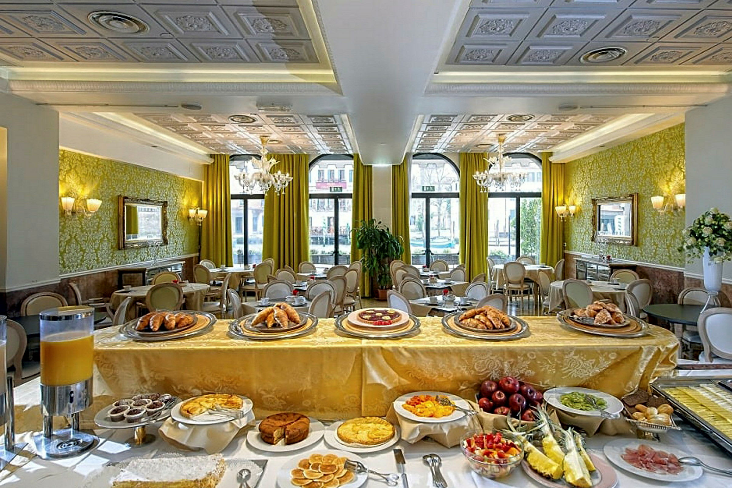 Ett elegant matsalsområde i en hotellrestaurang med en buffé med bröd, kakor och färsk frukt. (AI-genererad text)