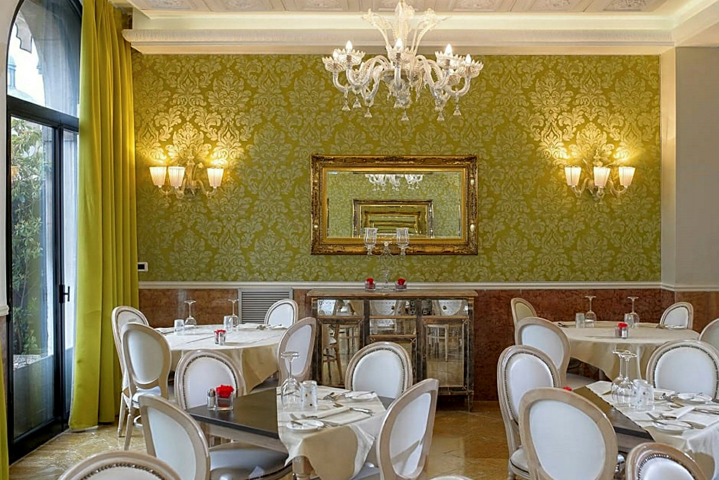 En restaurang med gröna väggar, stilfulla stolar och bord med dukar. (AI-genererad text)